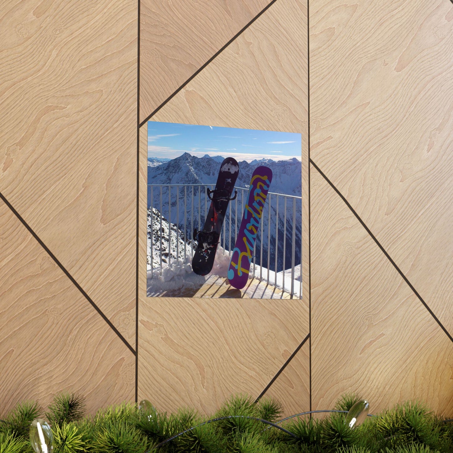 Two snowboards against a mountain backdrop on a wooden panel.