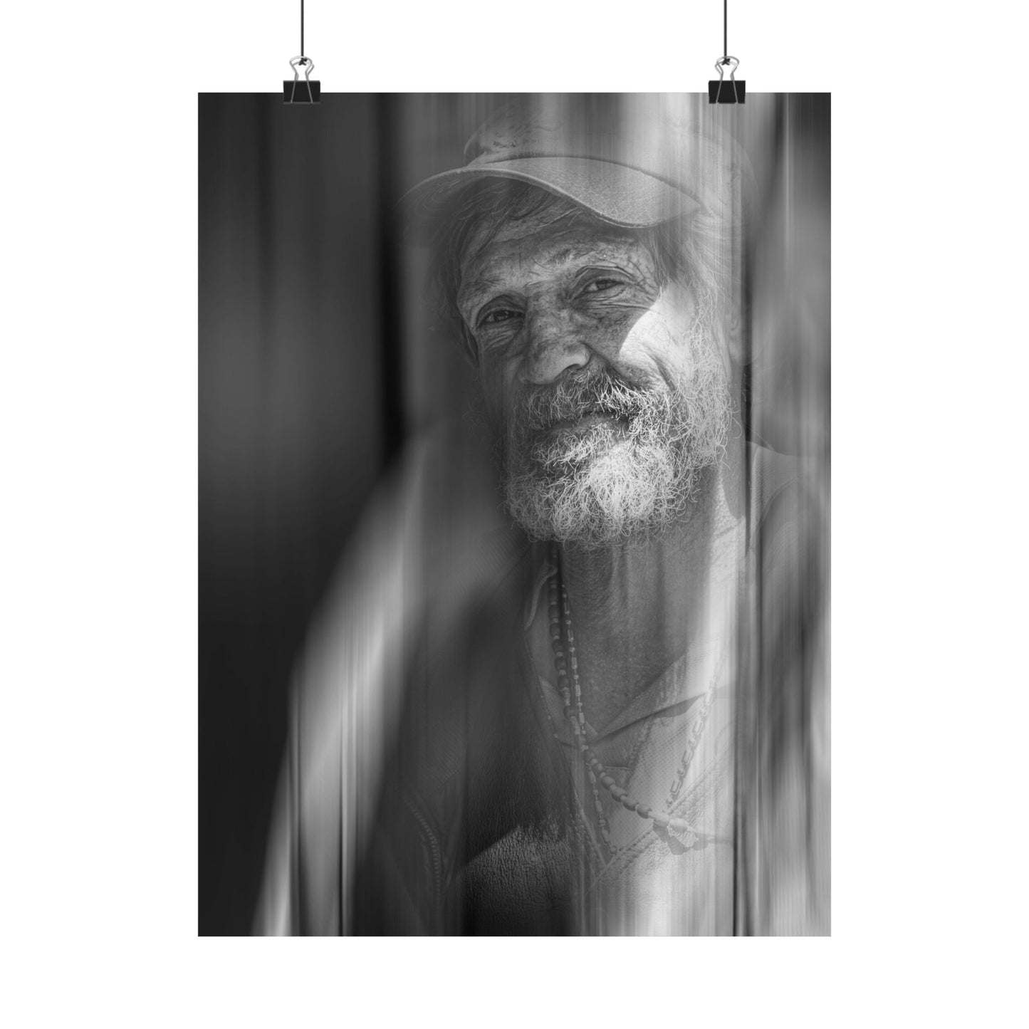 Black and white portrait of a man with a beard and headscarf, hanging on a white wall.