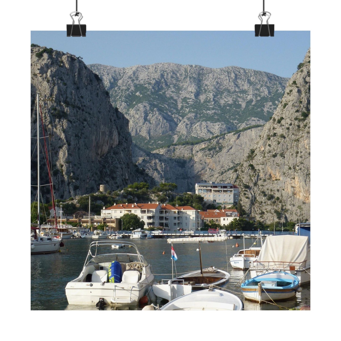 Harbor scene with boats and buildings against a mountainous background