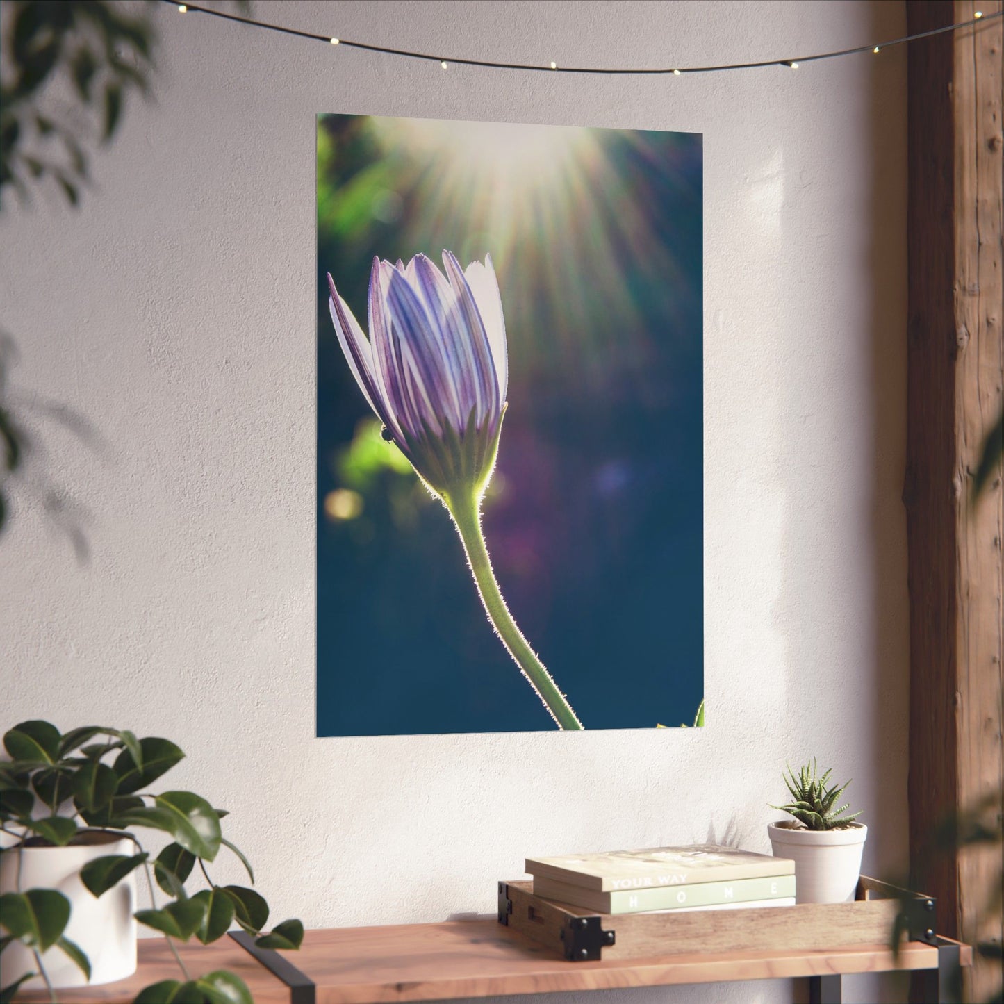 Floral tapestry hanging on a wall with a table and plants below