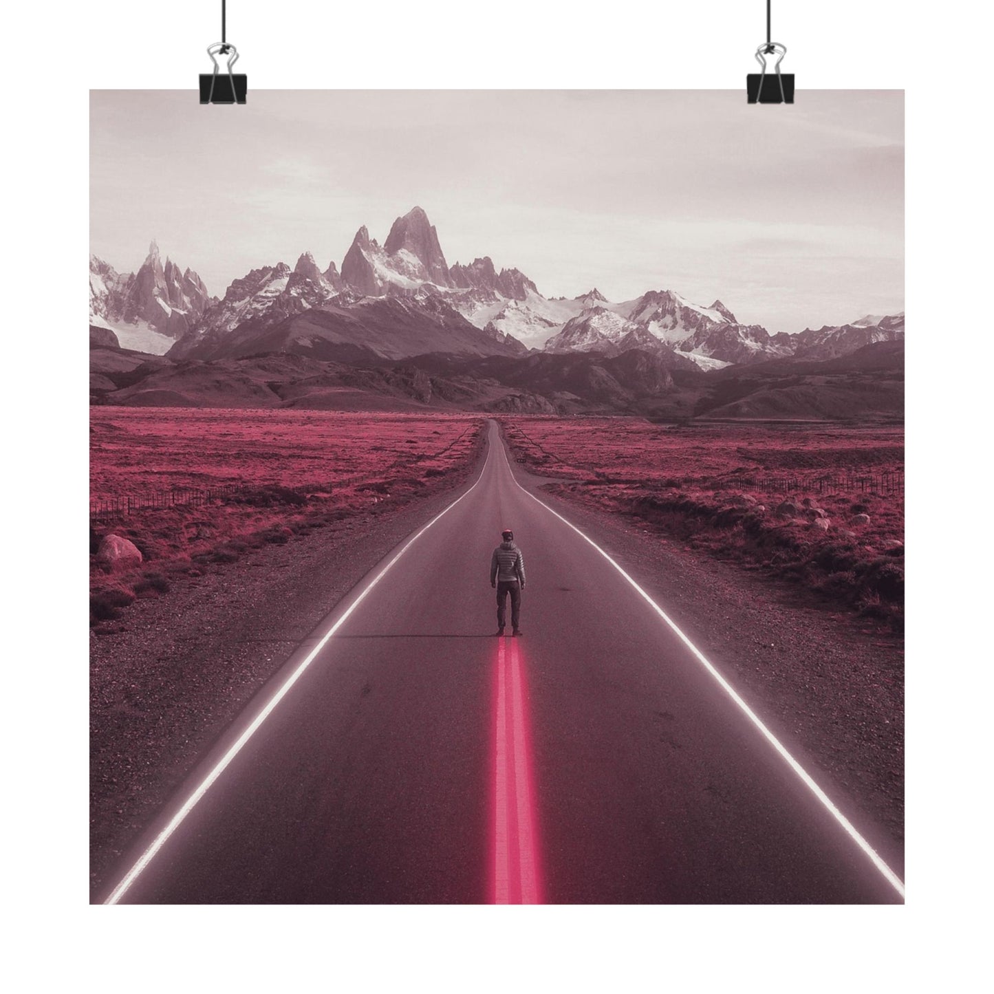 Person standing on a road with pink neon lights leading towards snow-capped mountains.