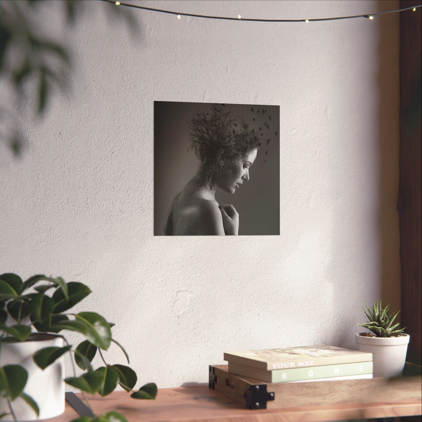 Poster of a woman with nature-themed hair on a wall above a wooden desk with plants and books.