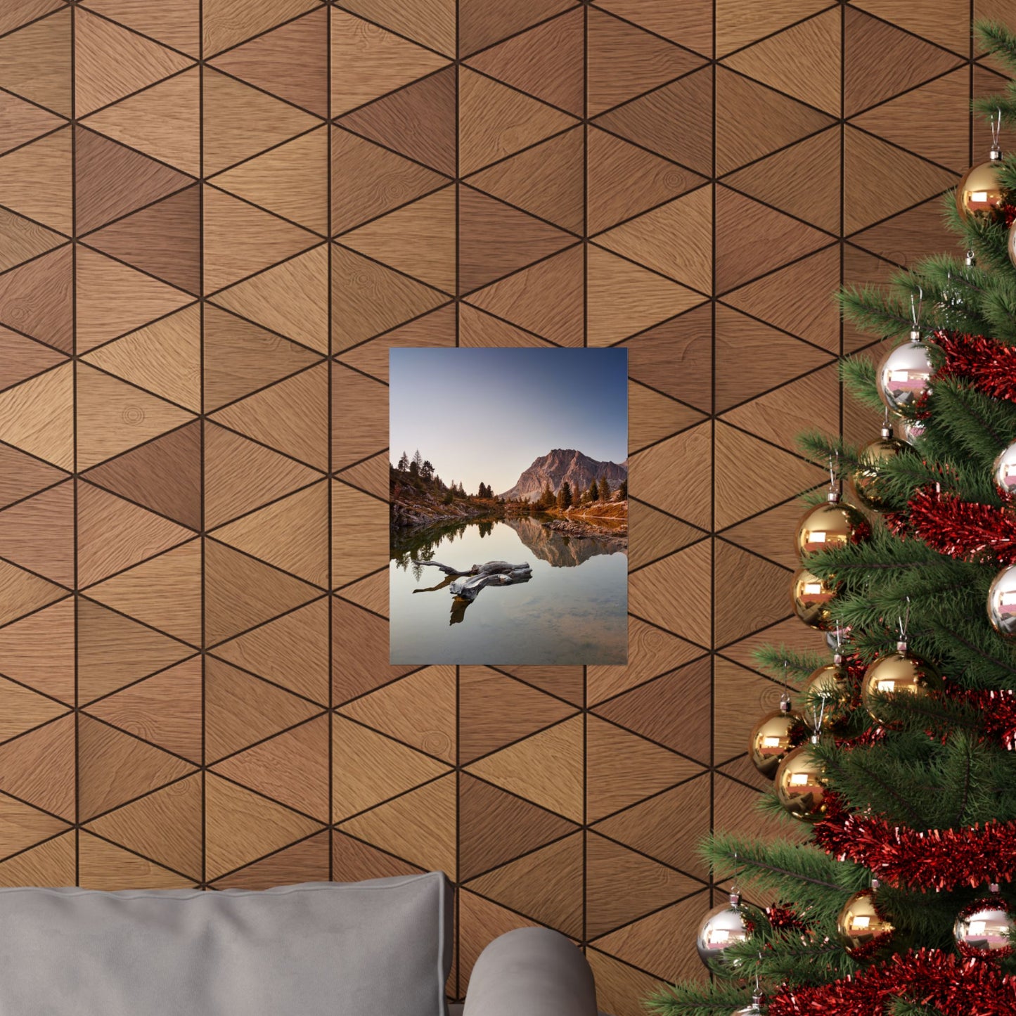 Wooden wall with geometric pattern, framed picture of a mountain lake, and Christmas tree with decorations.