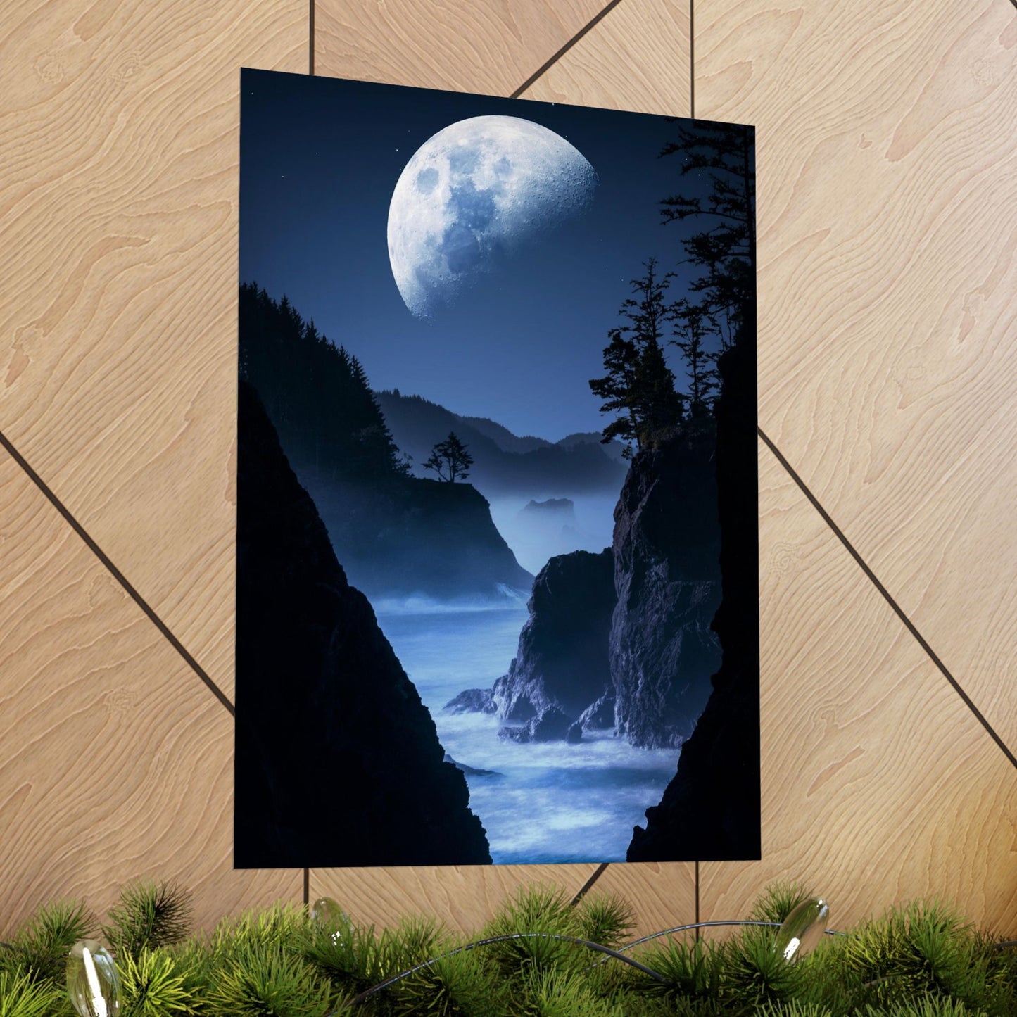 Poster of a moonlit landscape with cliffs and trees on a wooden floor.