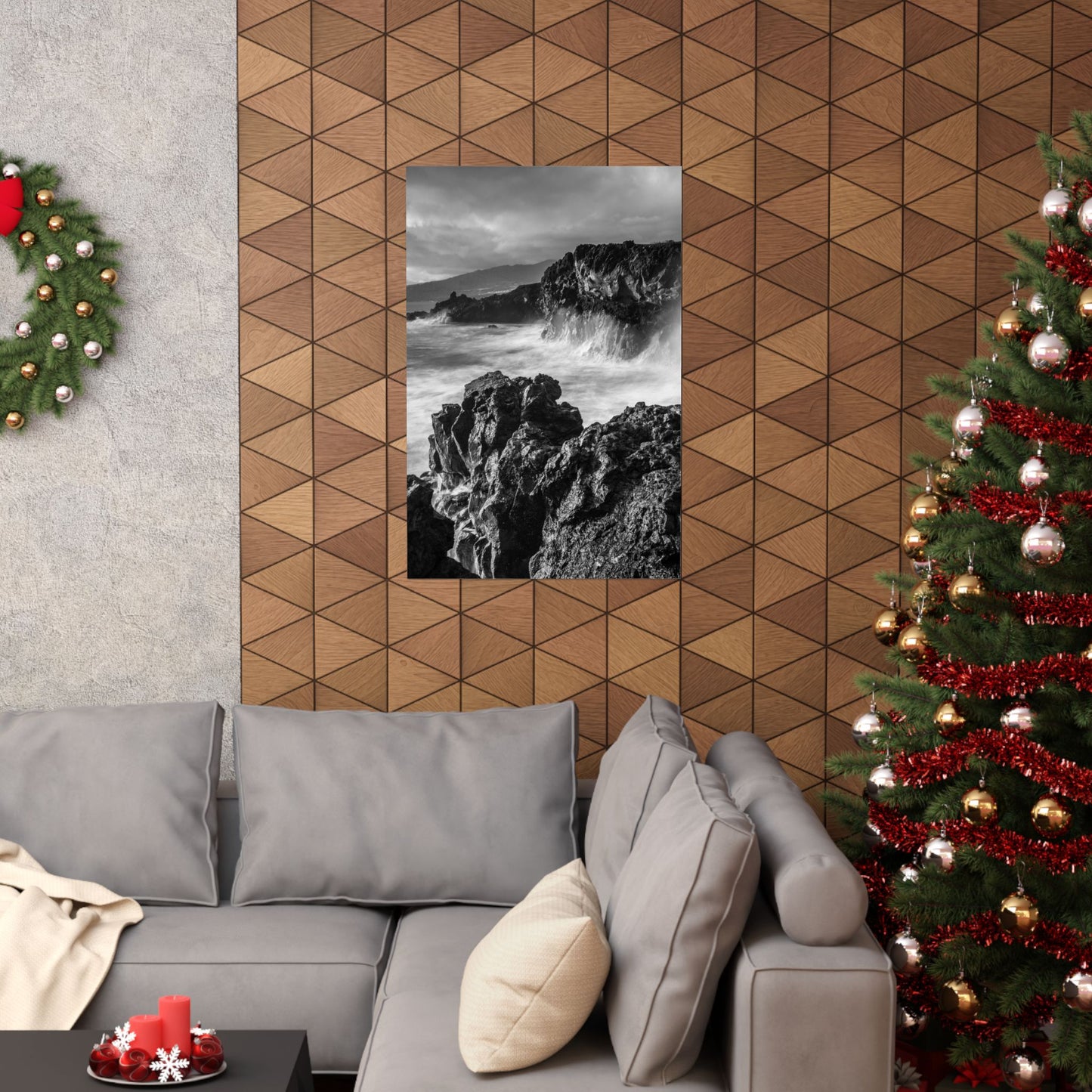 Living room with gray sofa, Christmas tree, and geometric wall design.
