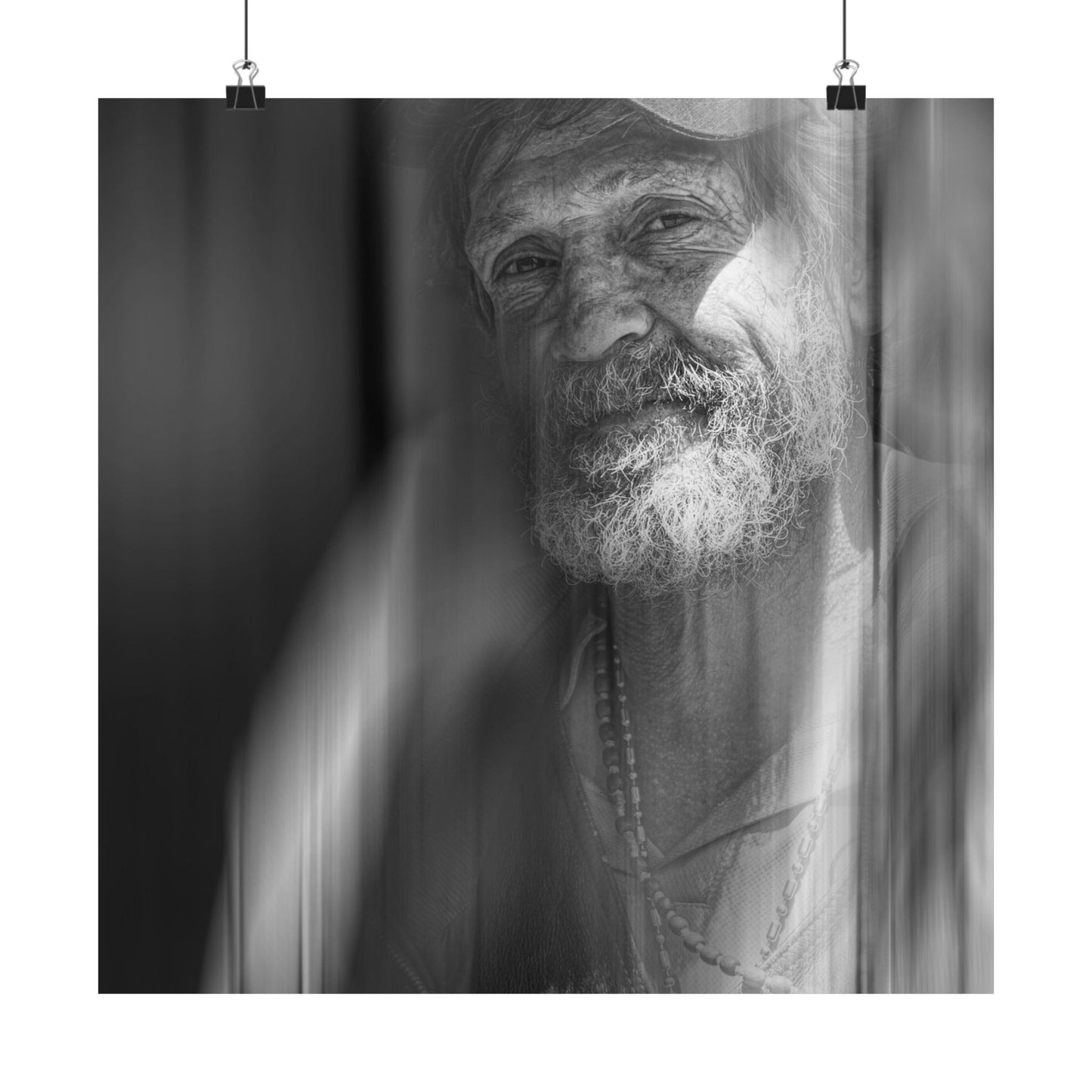 Black and white portrait of an elderly man with a beard and a necklace.