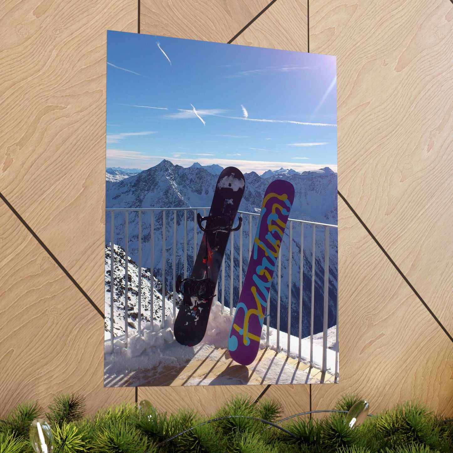 Two snowboards leaning against a railing with a mountainous landscape in the background.