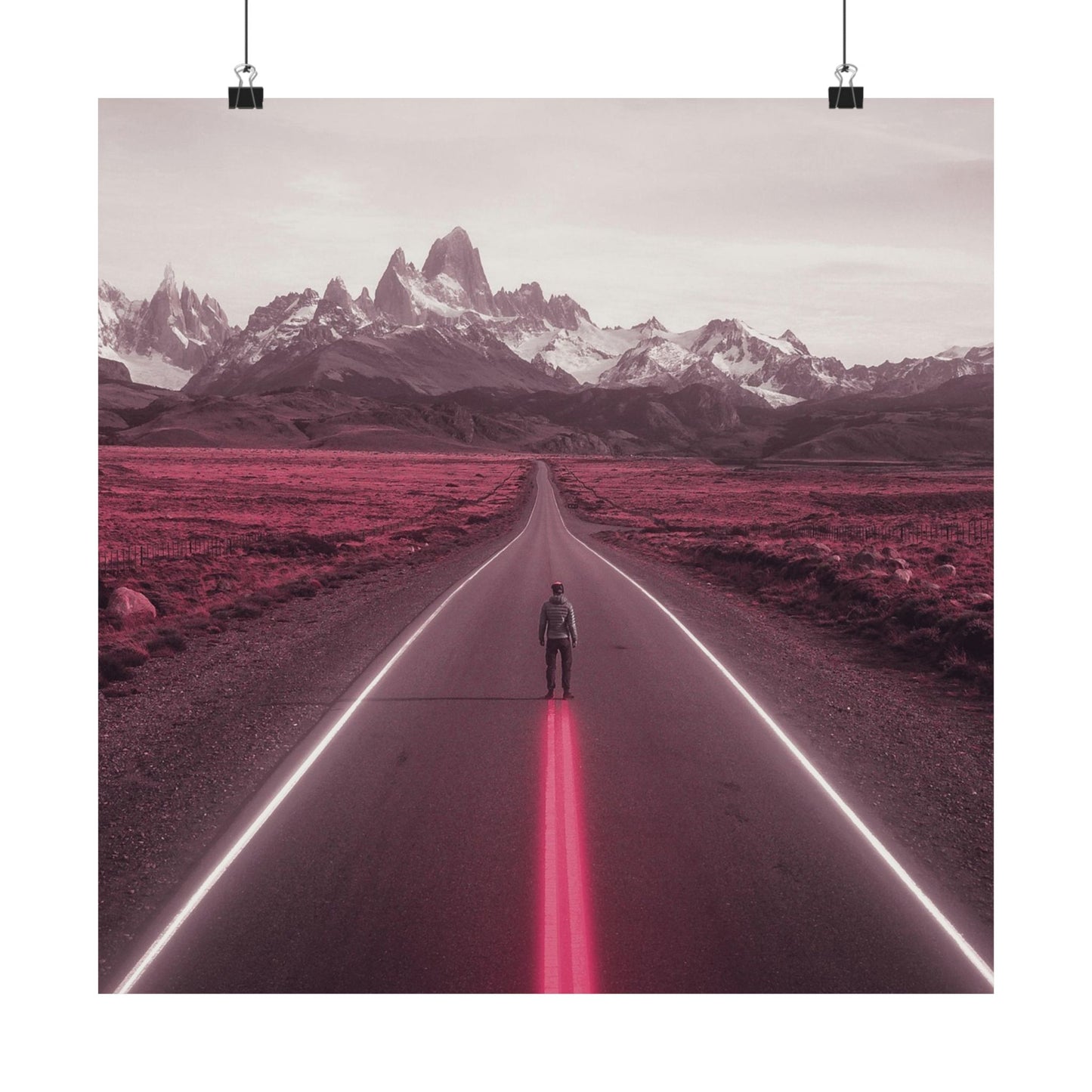 Person standing on a road with pink neon lights leading towards mountains