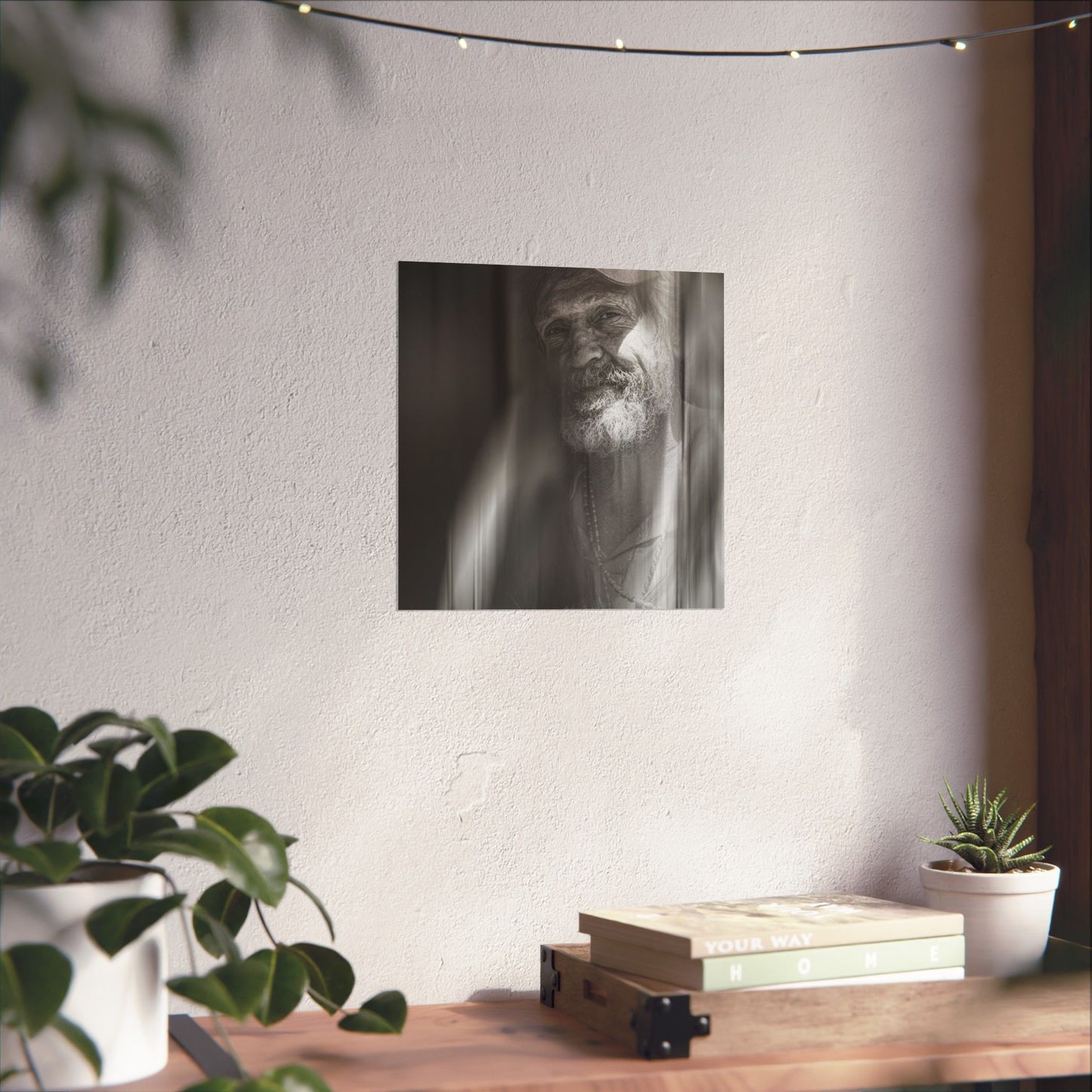 Poster of a man on a wall above a wooden shelf with books and plants.