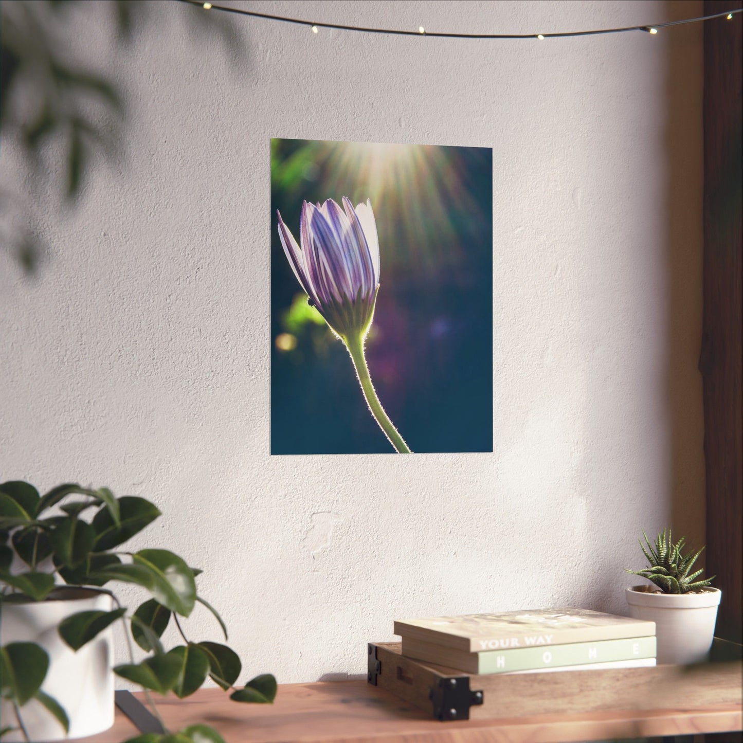 Flower painting on a wall above a wooden desk with plants
