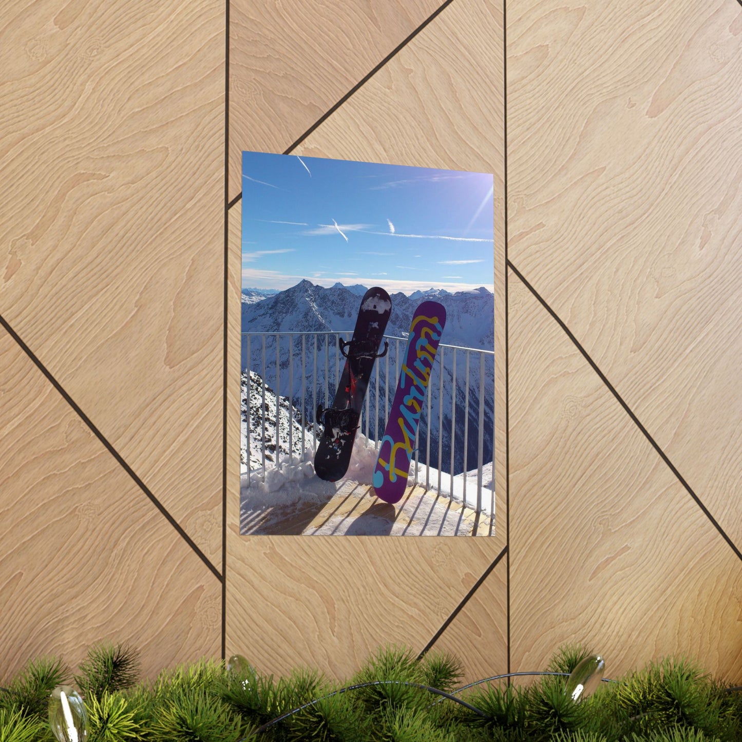 Two snowboards against a mountain backdrop on a wooden surface.