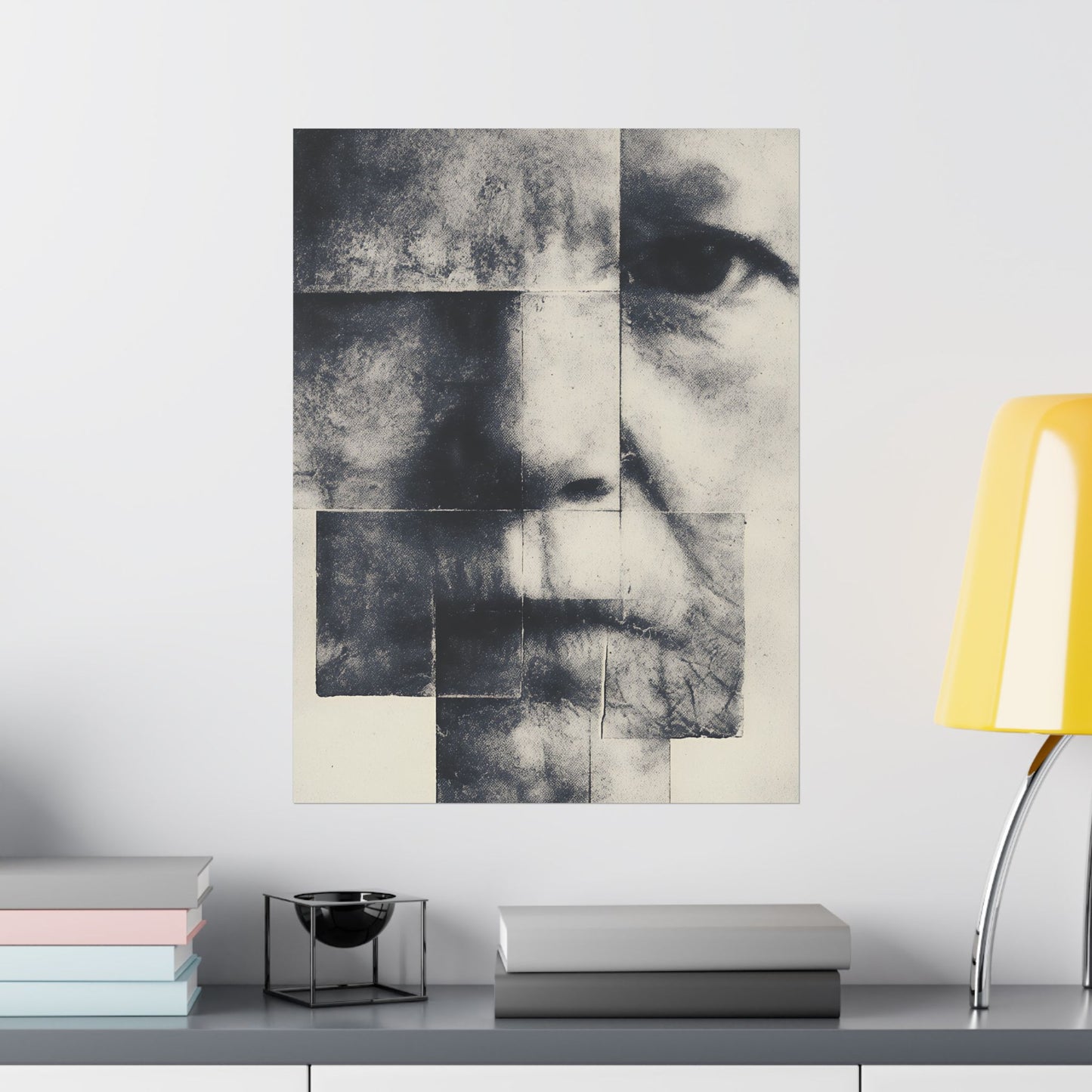 Abstract art piece on a wall above a shelf with books and a lamp.