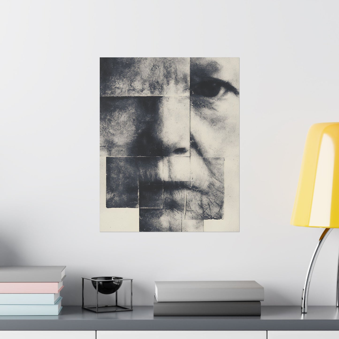 Abstract art piece on a wall above a shelf with books and a lamp.