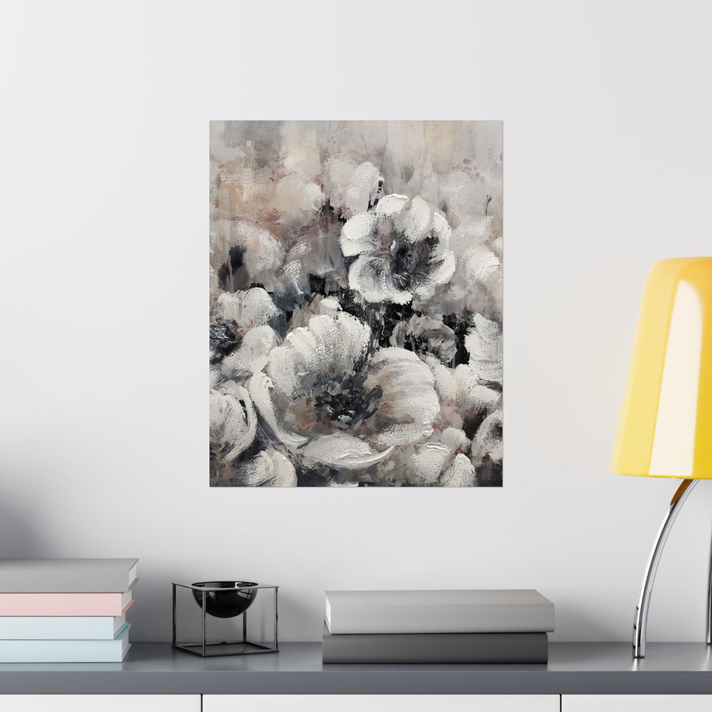 Floral painting on a wall above a shelf with books and a lamp.