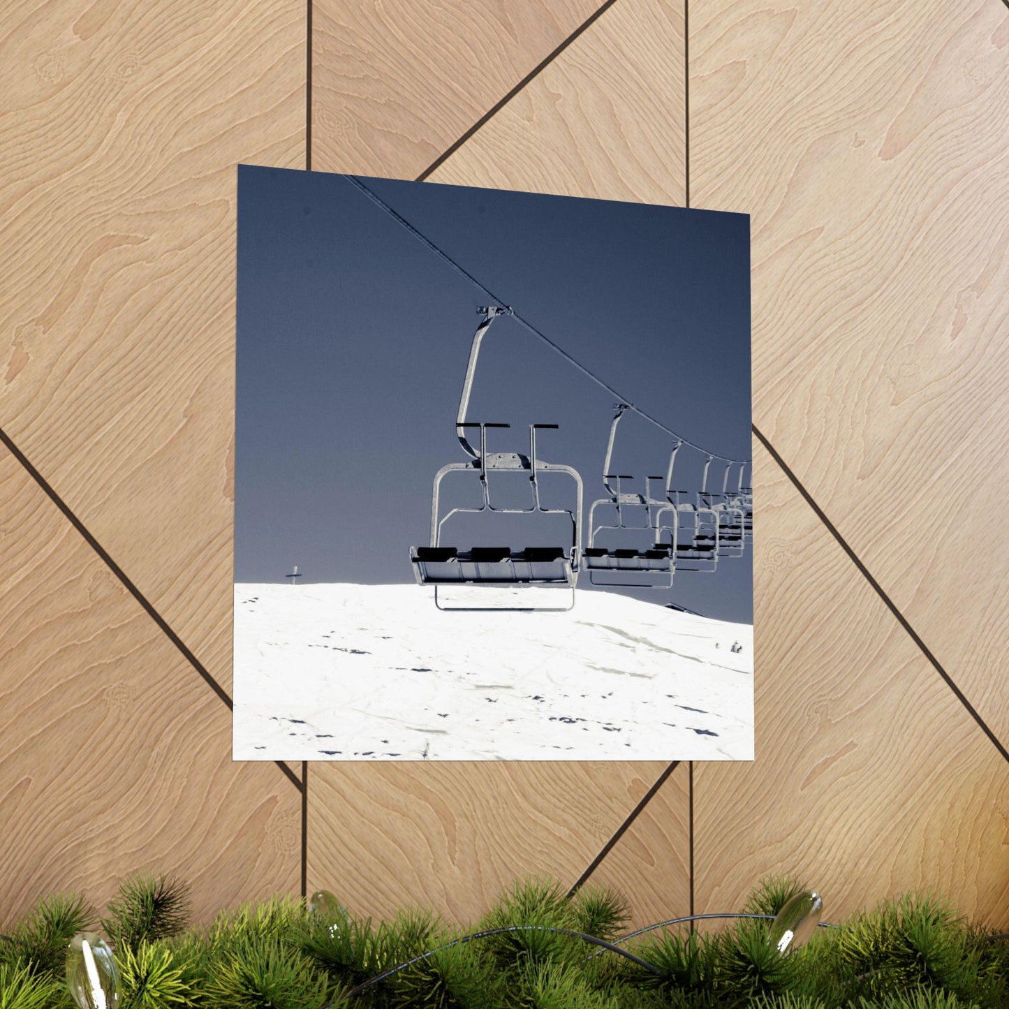 Ski lift against a blue sky on a wooden surface with grass at the bottom.