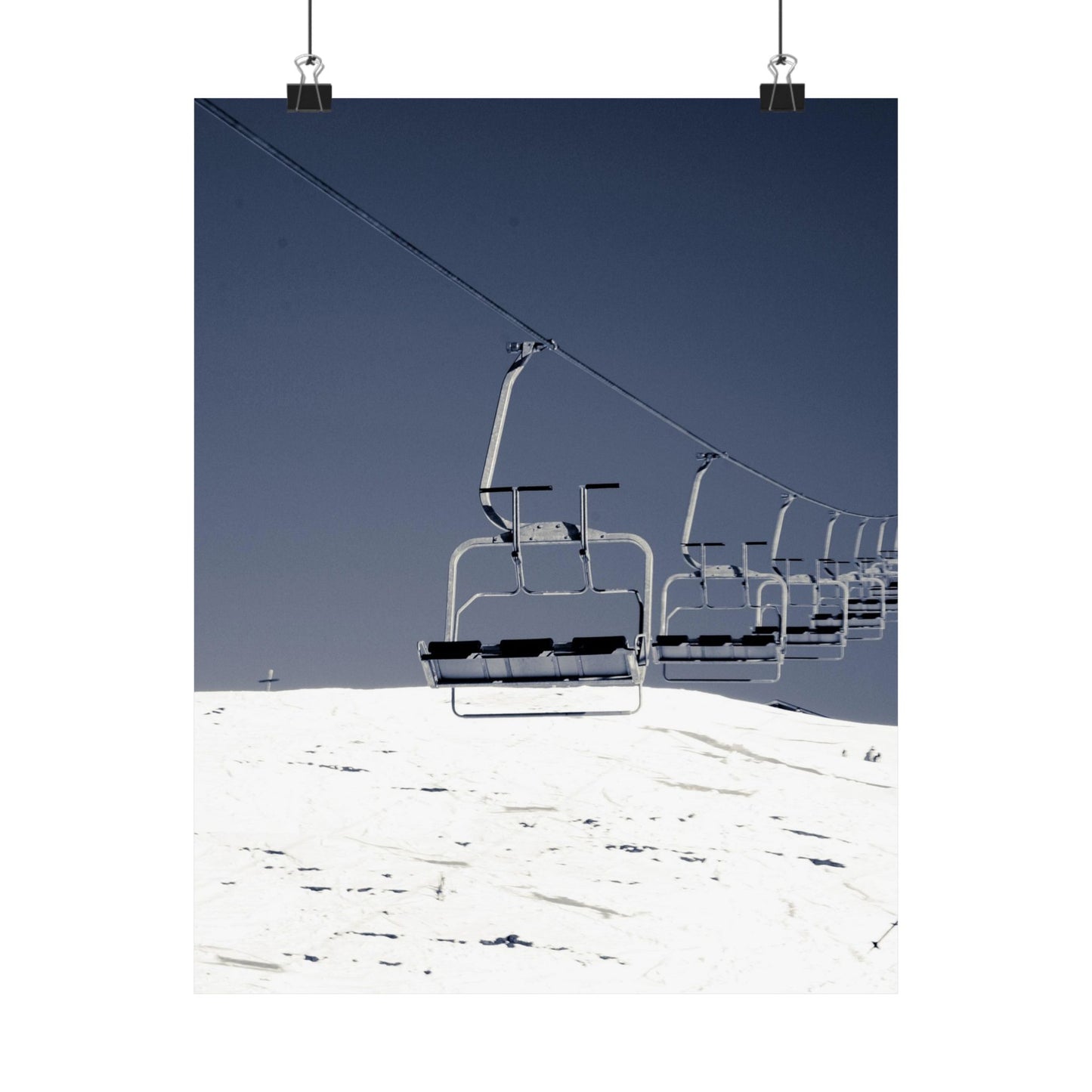 Ski lift on a snowy mountain with clear blue sky
