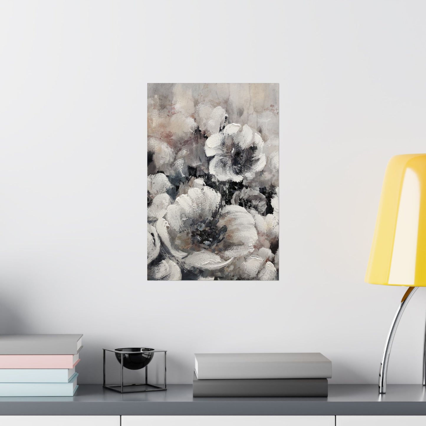Floral painting on a wall above a shelf with books and a lamp.