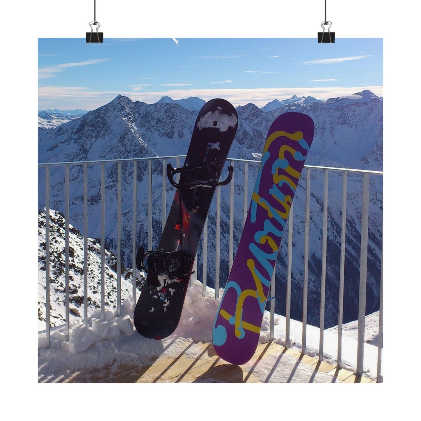 Two snowboards against a mountainous background