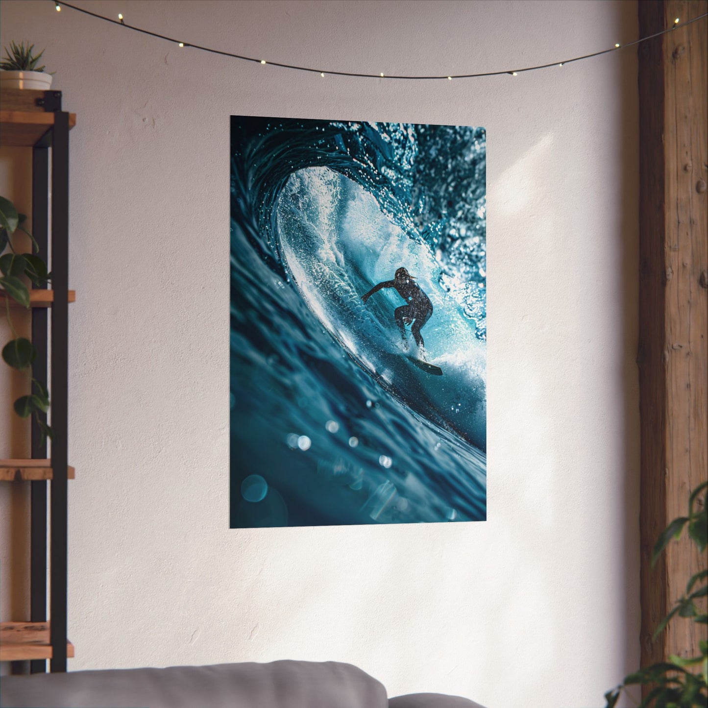 Poster of a surfer riding a wave on a wall in a room with a plant and shelf.