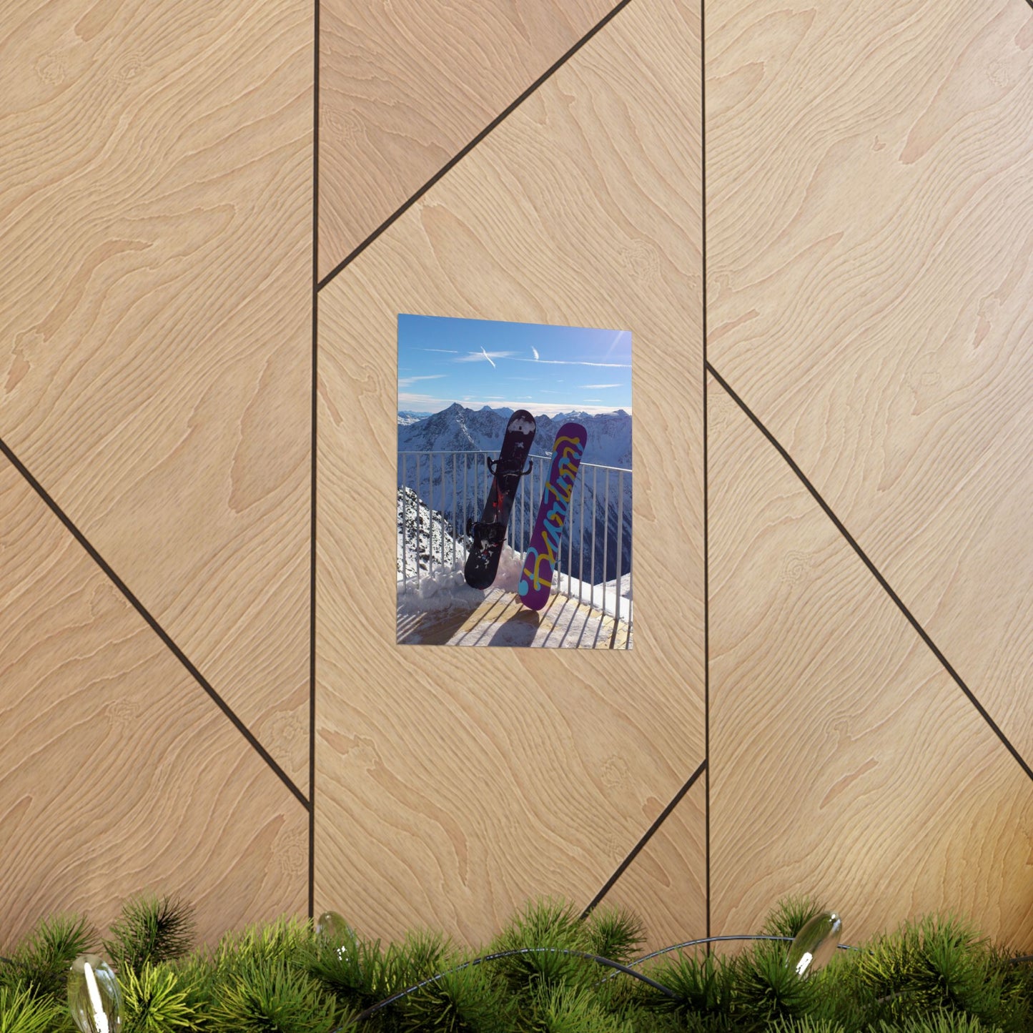 Wooden wall with a framed picture of a person with skis and colorful pants against a mountain backdrop.
