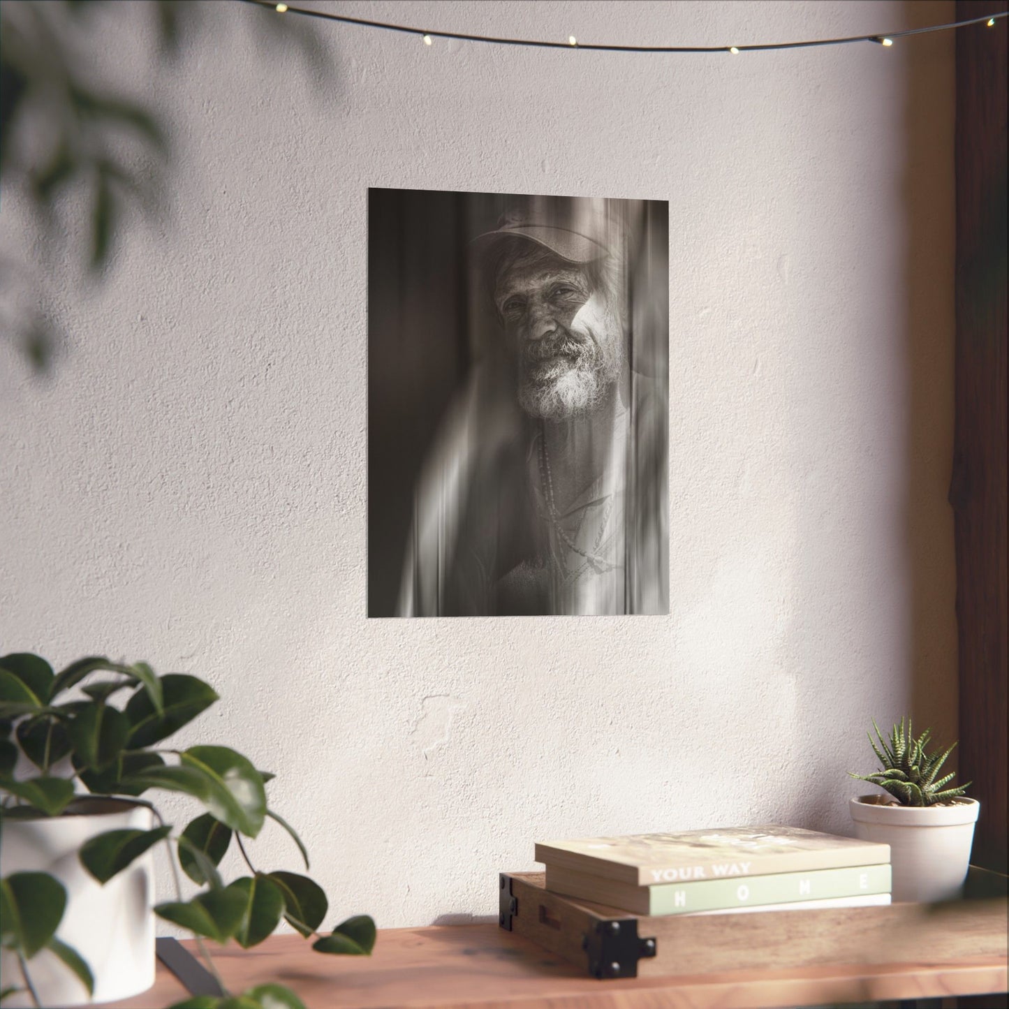 Poster of a man with a beard on a wall above a wooden shelf with books and plants.
