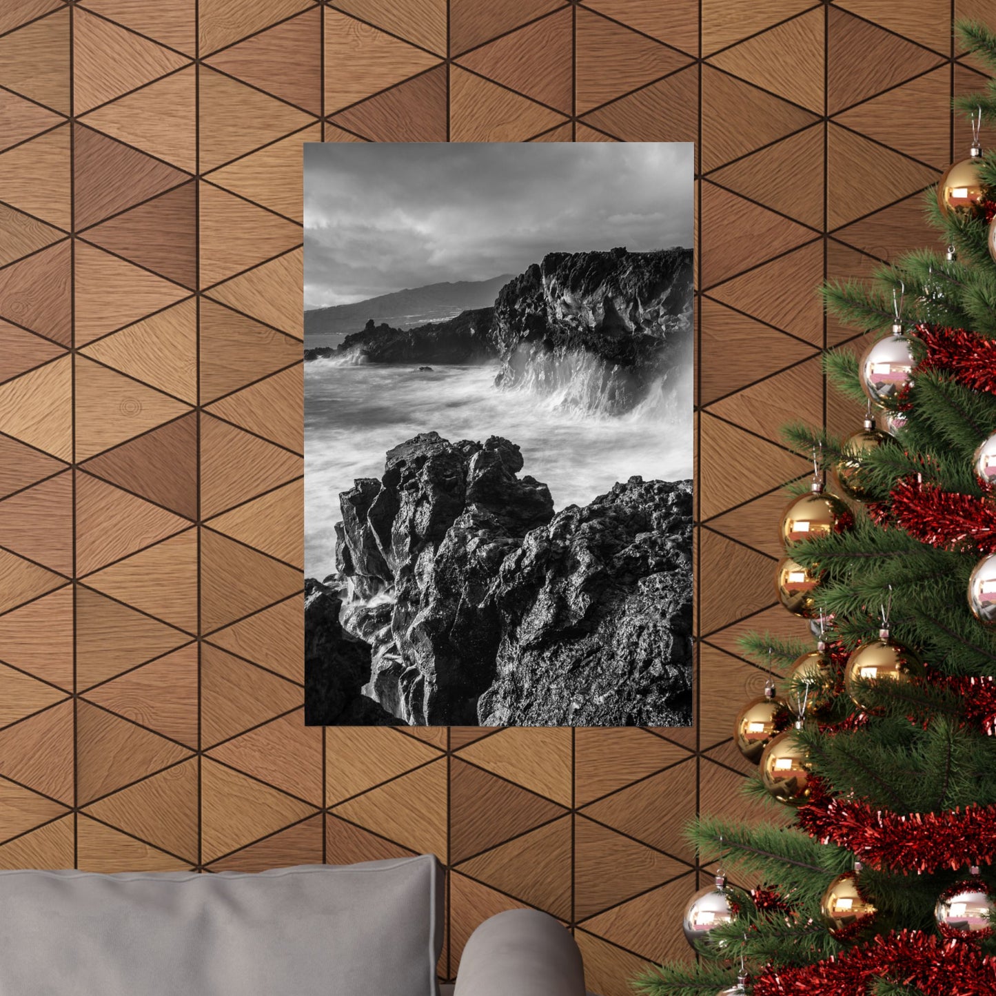 Decorative wall with geometric pattern, framed black and white photo of rocky landscape, and Christmas tree with ornaments.