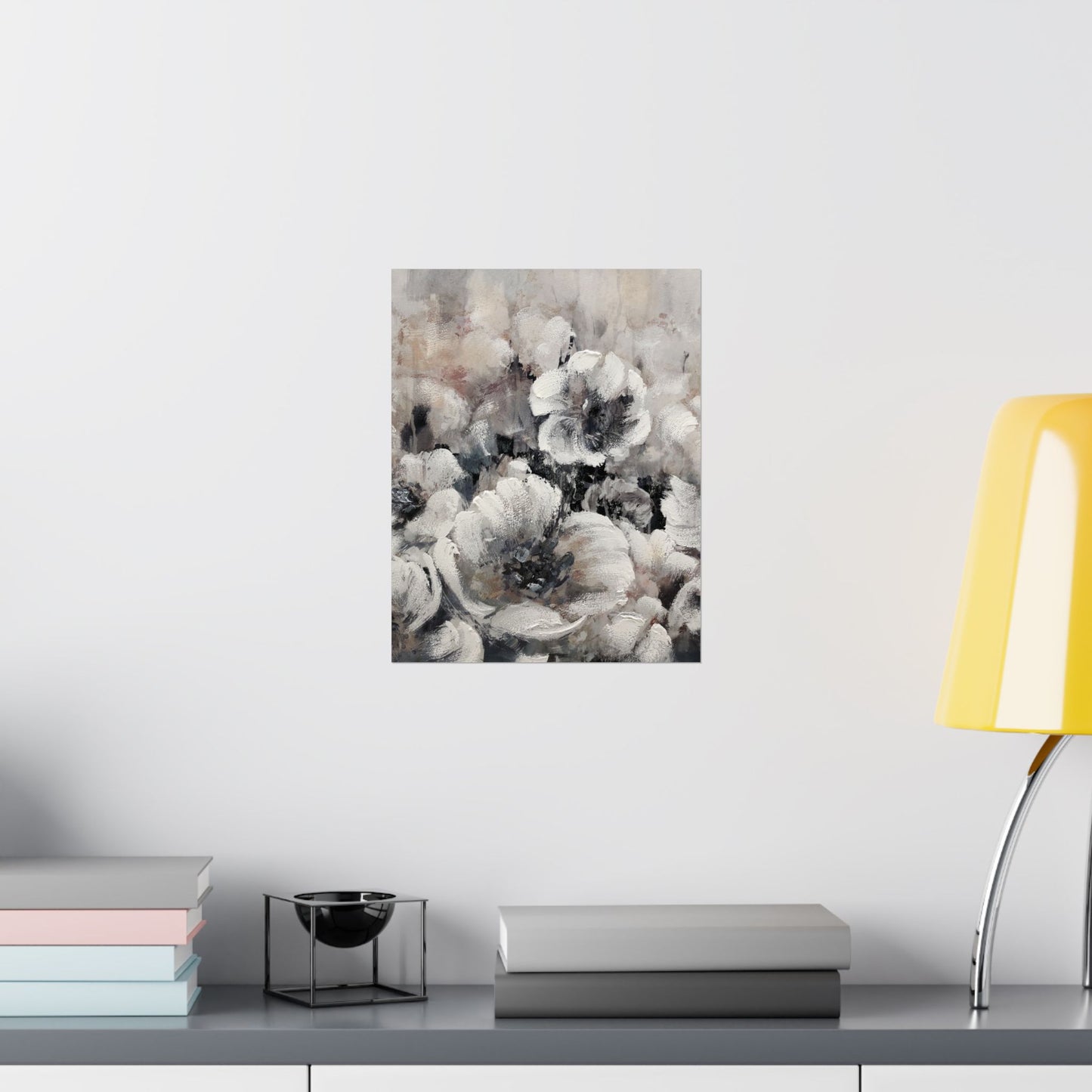 Floral painting on a wall above a shelf with books and a lamp.