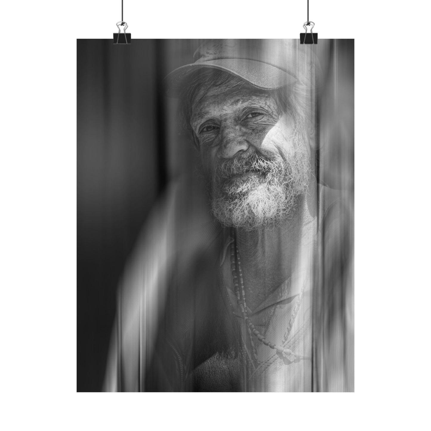 Black and white portrait of a man with a beard and cap, framed by leaves.