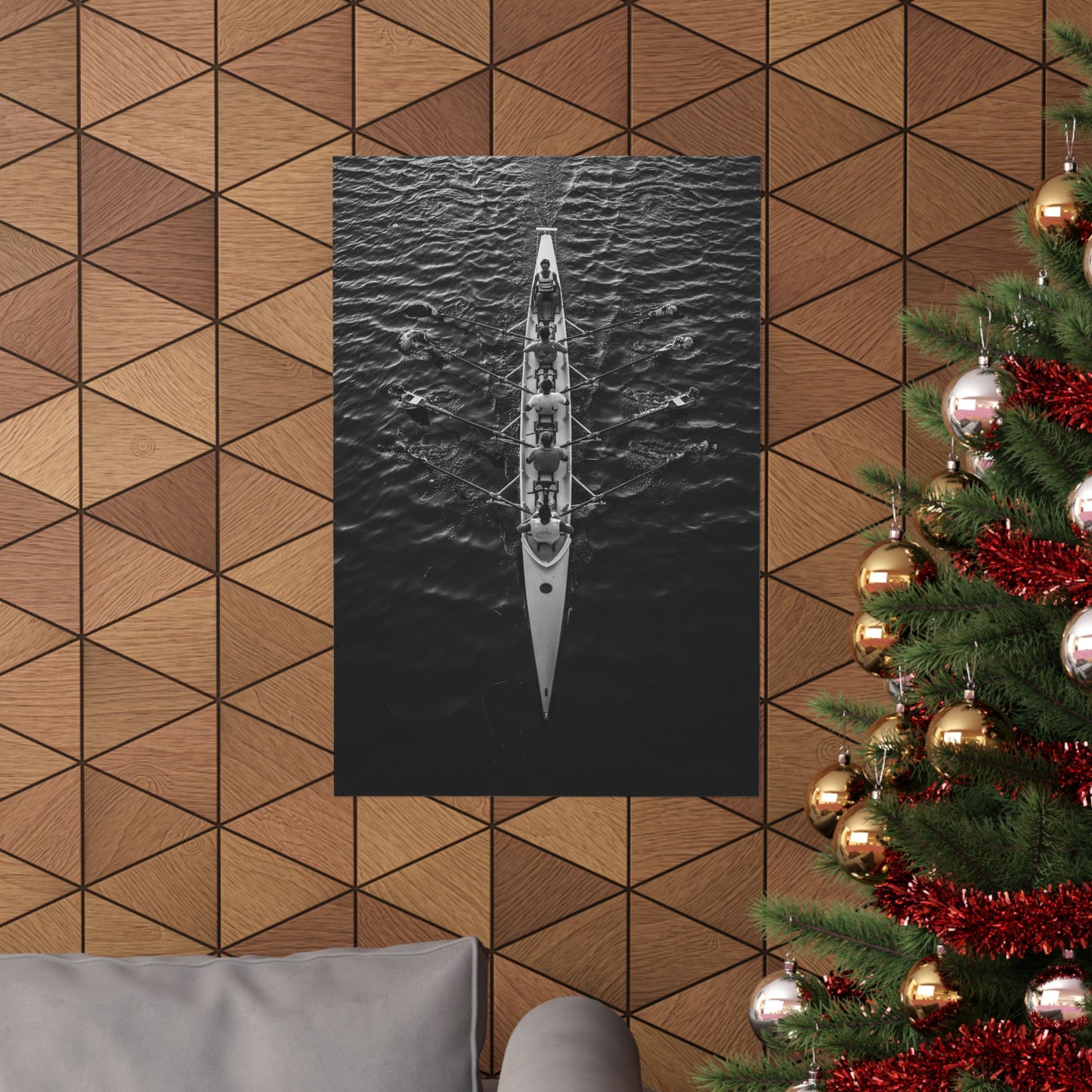 Poster of a kayak on water hanging on a geometric-patterned wall with a Christmas tree to the right.