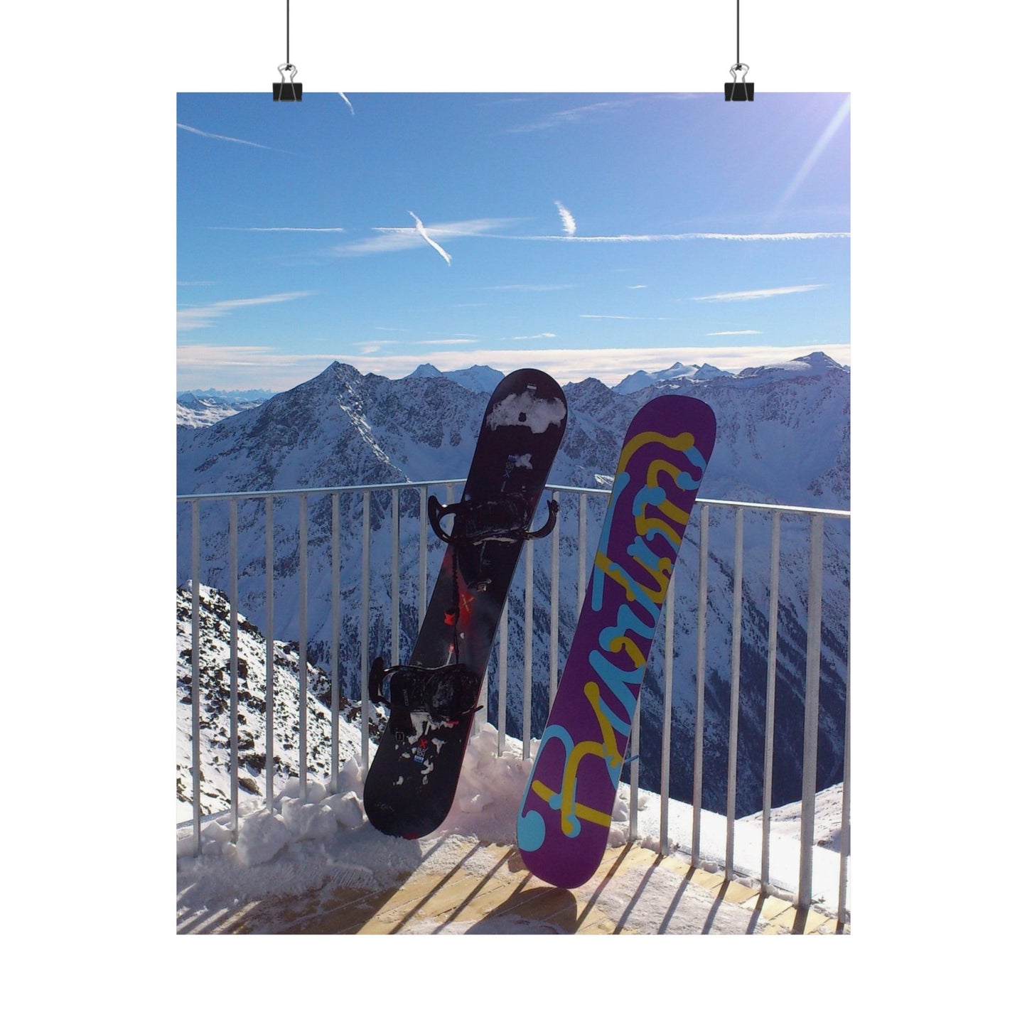 Two snowboards against a mountainous landscape