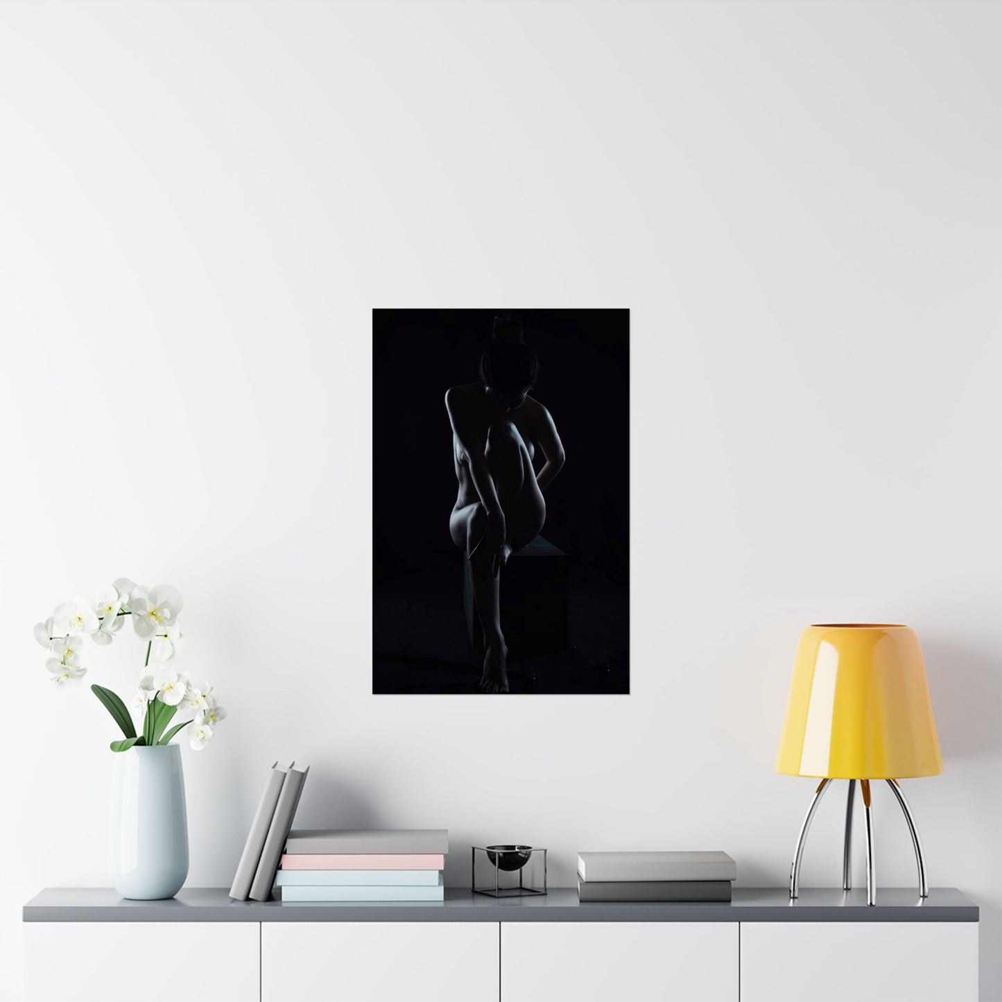 Silhouette art print on a wall above a table with decor items.