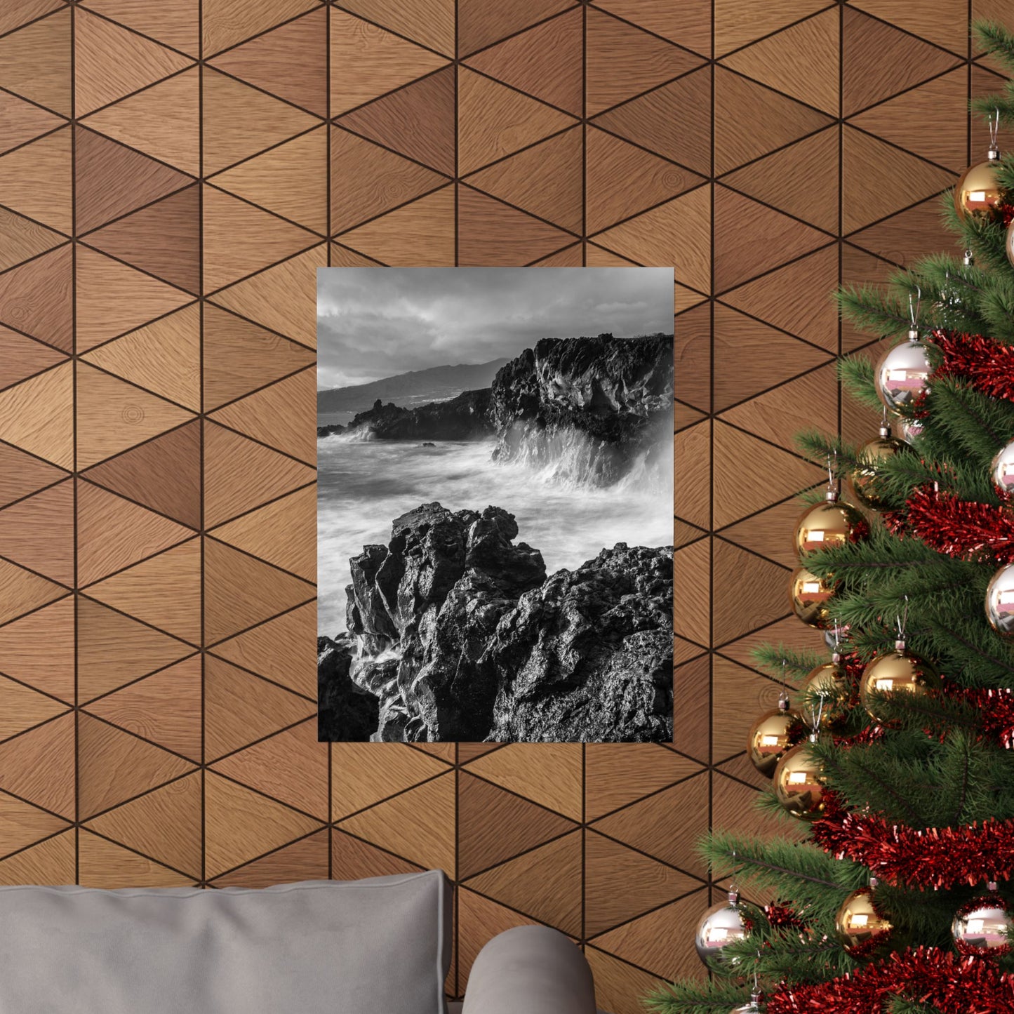 Decorative wall with geometric wood pattern, framed black and white photo of rocky landscape, and Christmas tree with ornaments.