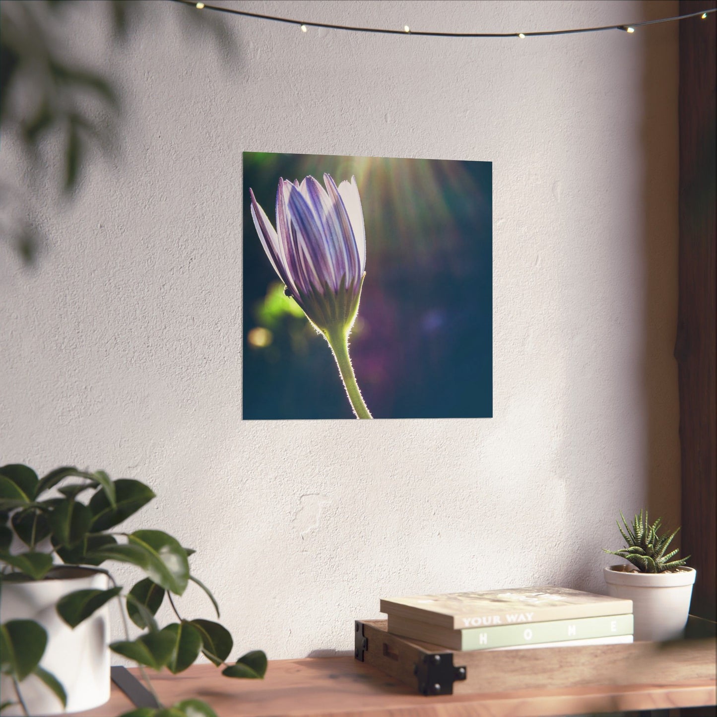 Flower painting on a wall above a wooden table with plants