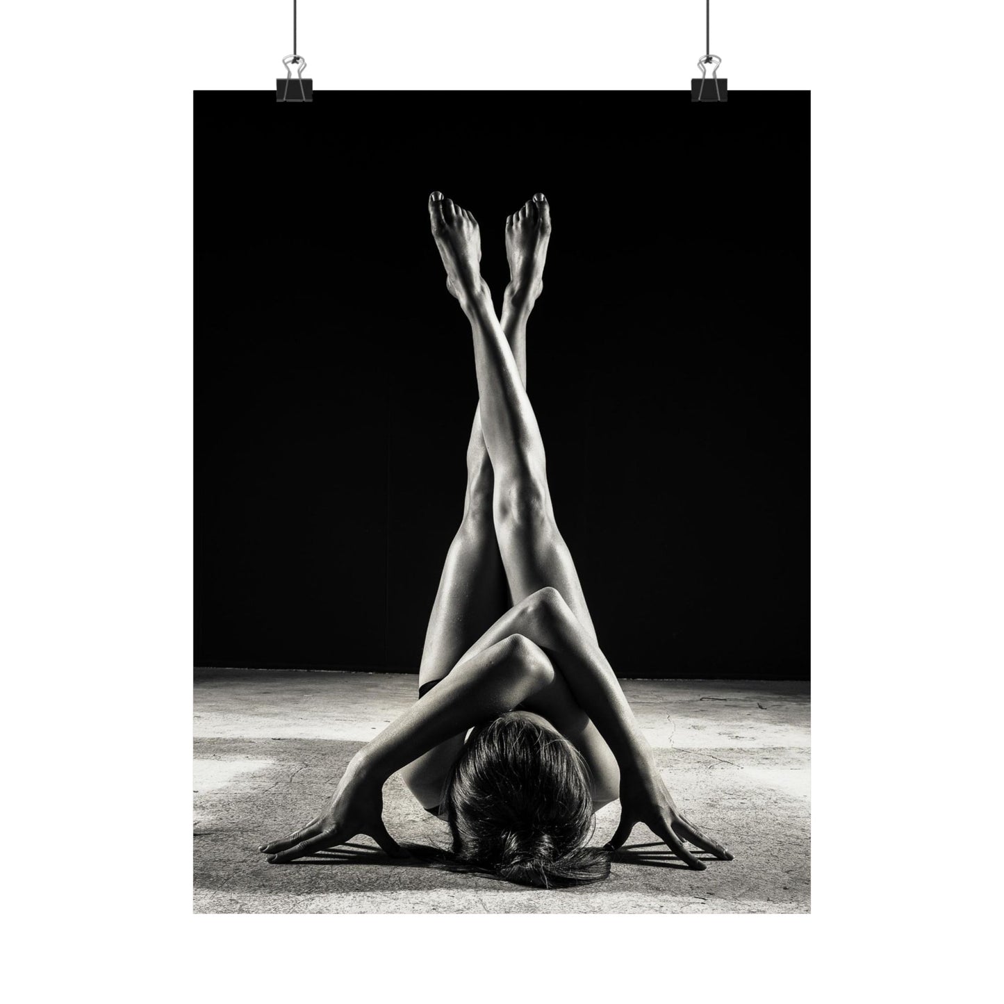 Black and white photograph of a person in a yoga pose with legs extended upwards.