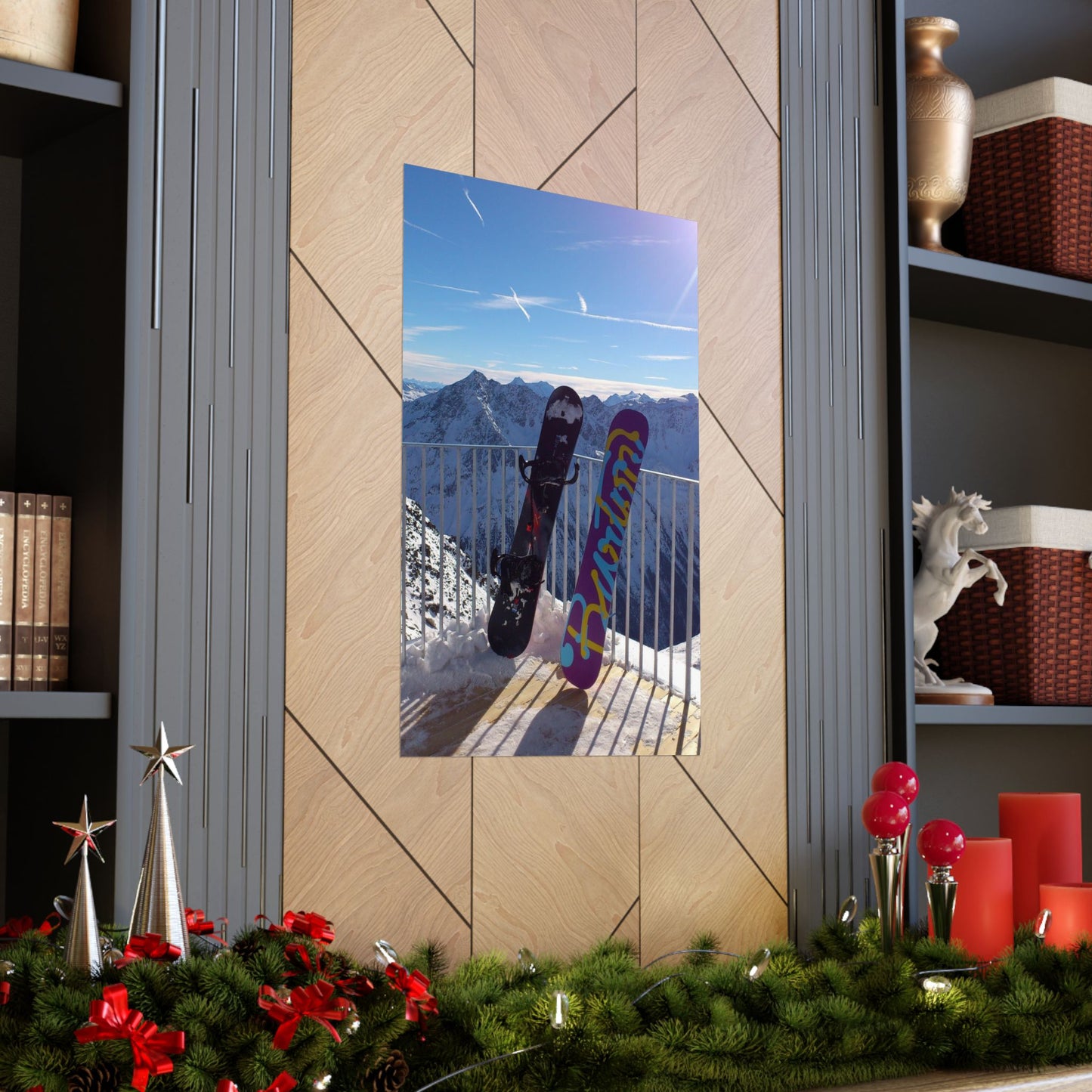Decorative mirror with a mountain and snowboard scene on a wall with festive decorations at the bottom.