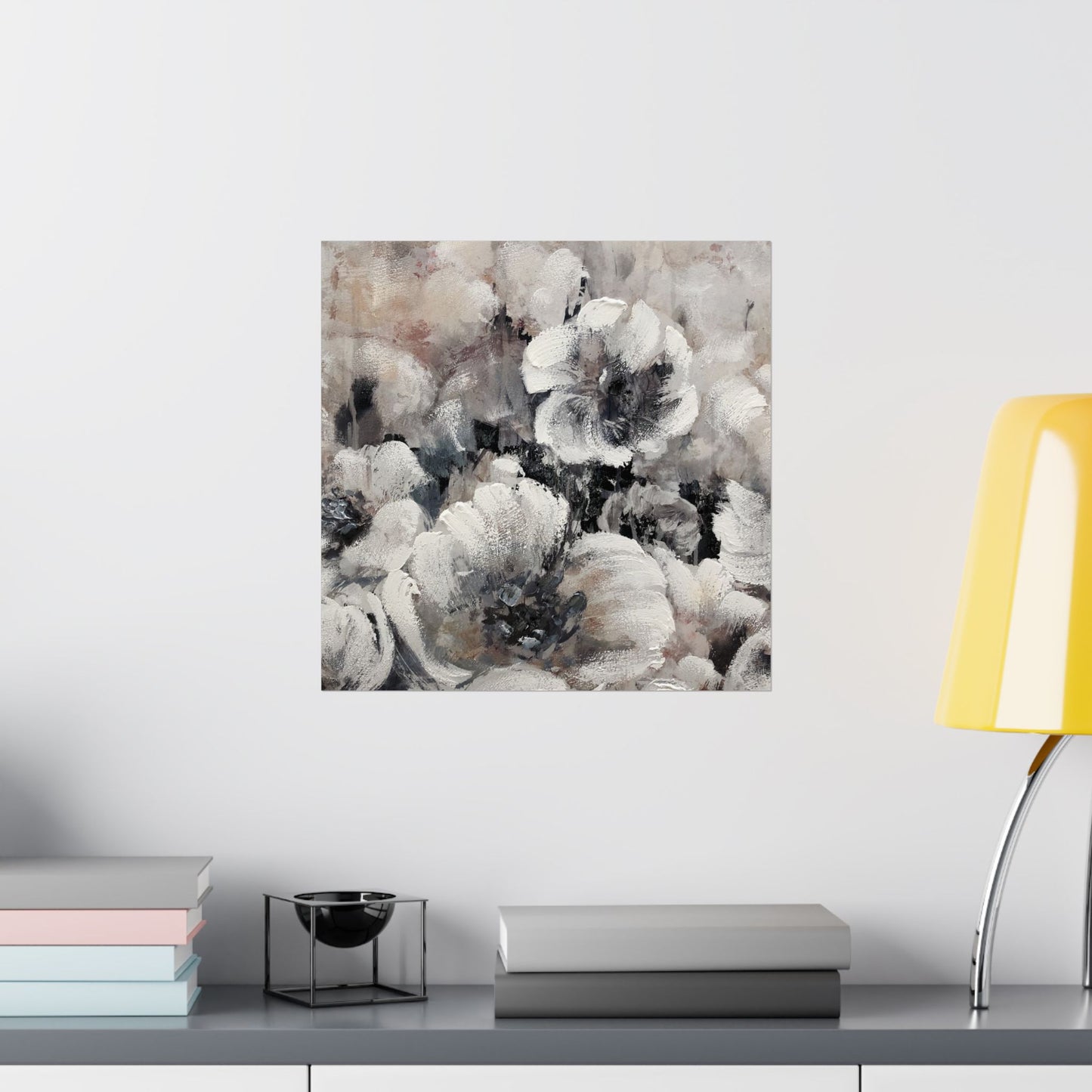 Abstract floral painting on a wall above a shelf with books and a lamp.