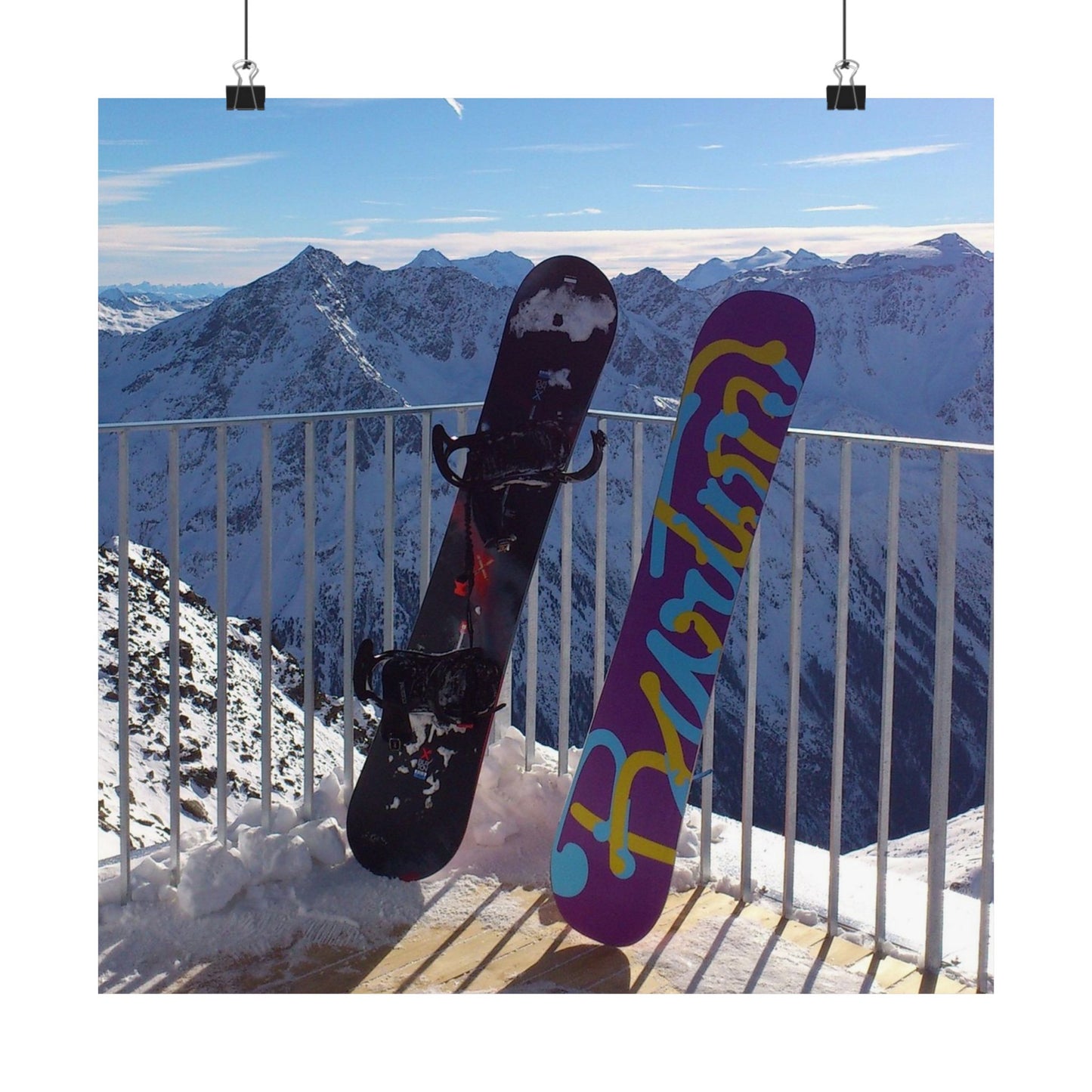 Two snowboards against a mountainous background