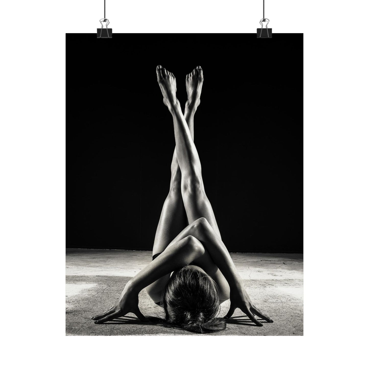 Black and white photo of a person in a yoga pose with a dark background