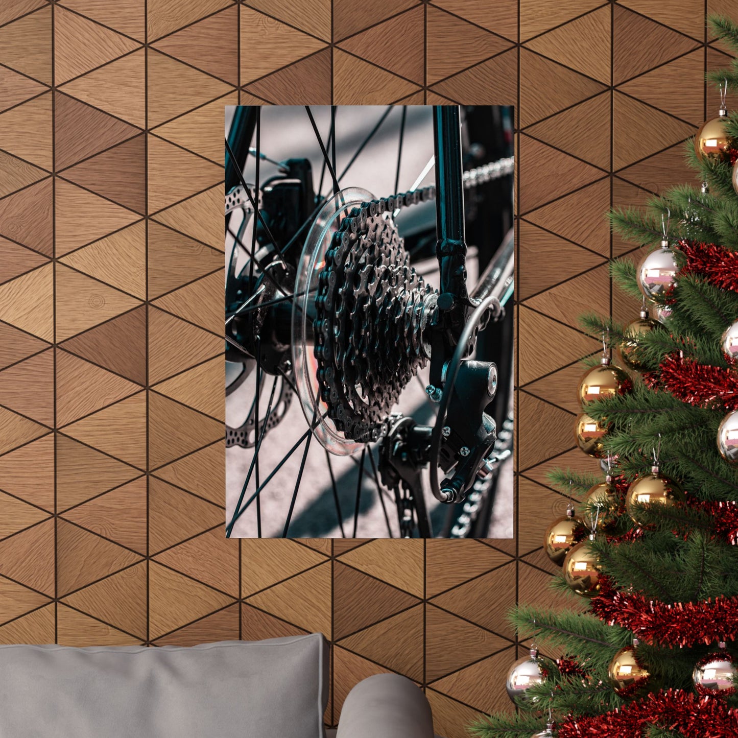 Poster of a bicycle gear system on a geometric-patterned wall with a decorated Christmas tree.