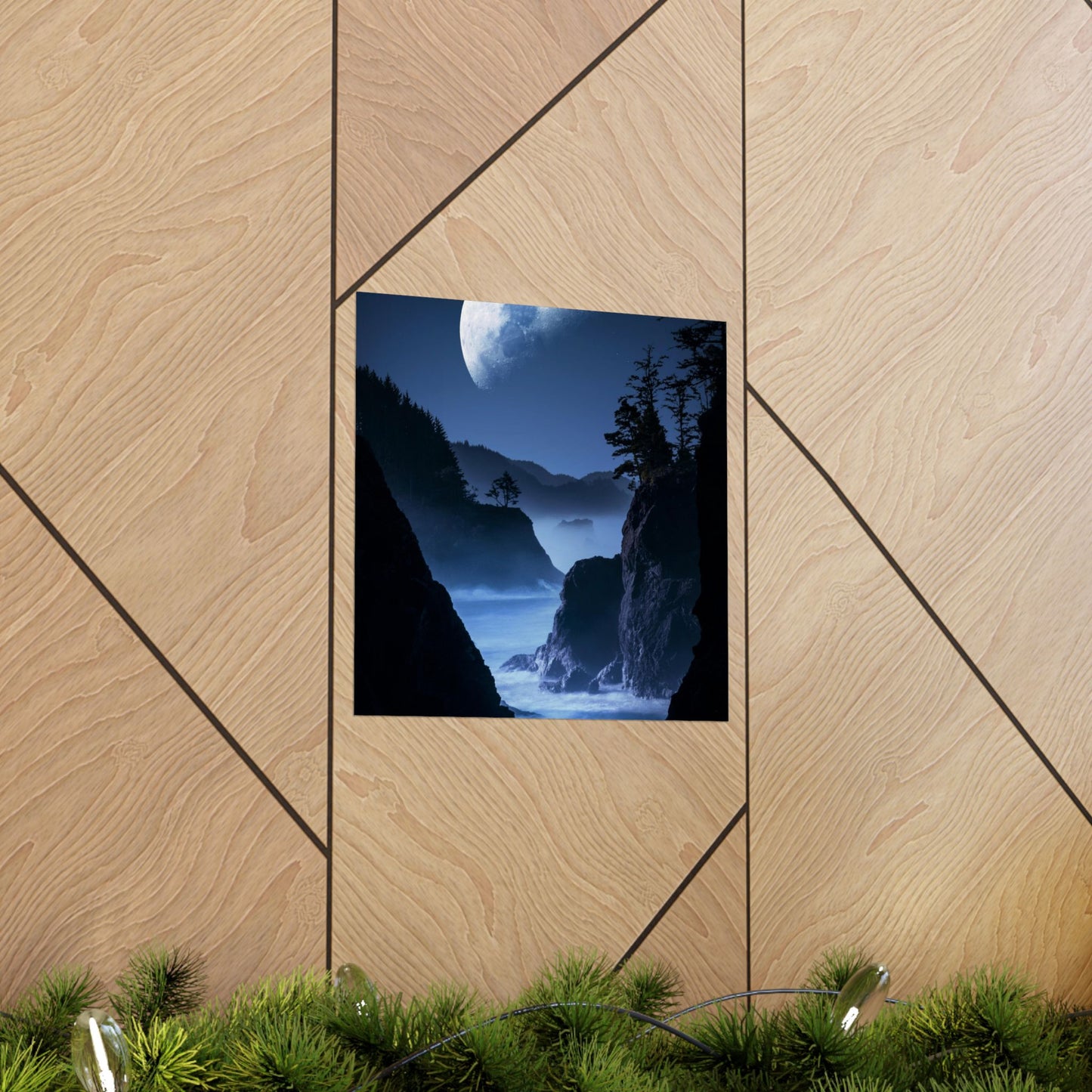 Framed landscape print of a mountainous scene with a moonlit sky on a wooden wall.