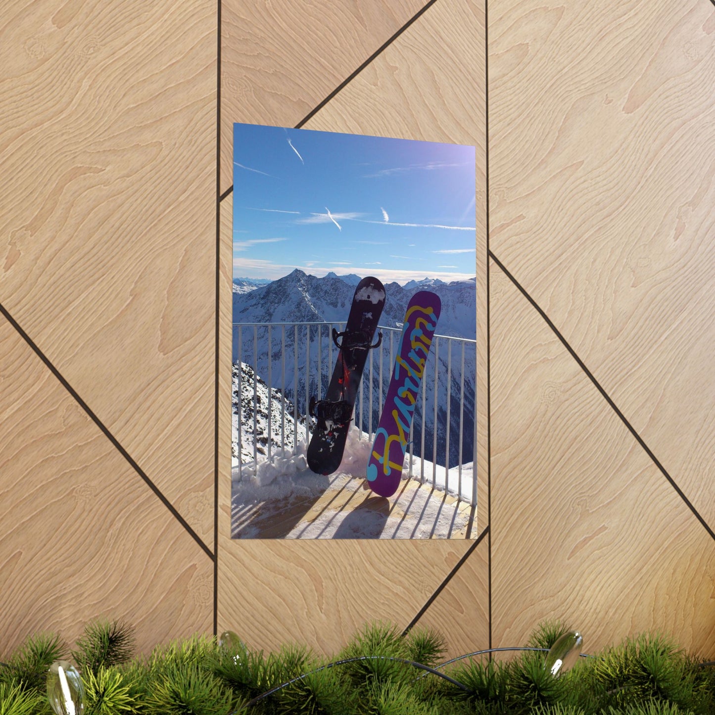 Two snowboards against a mountain backdrop on a wooden panel.