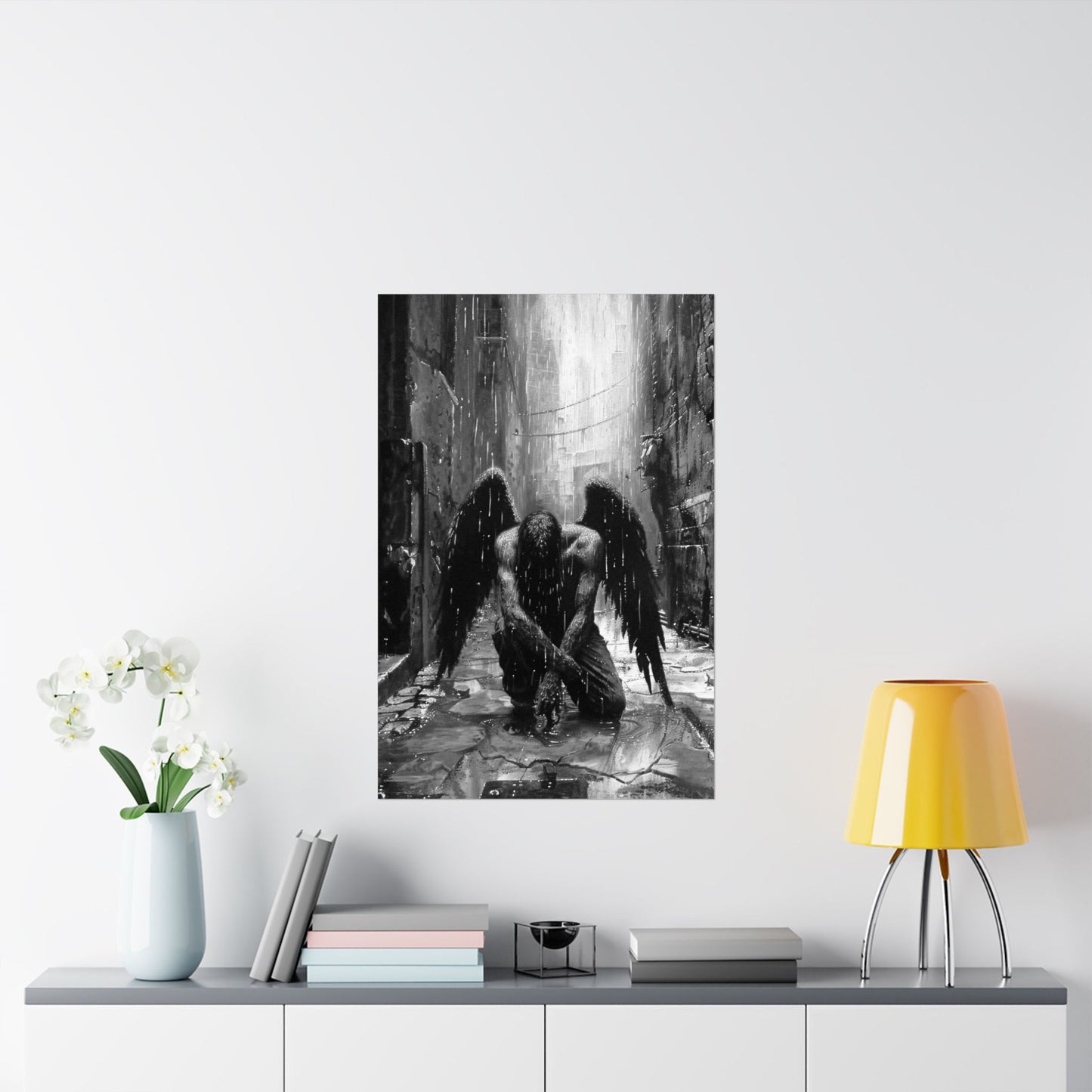Framed artwork of an angel in a dark alleyway on a wall above a shelf with decor items.