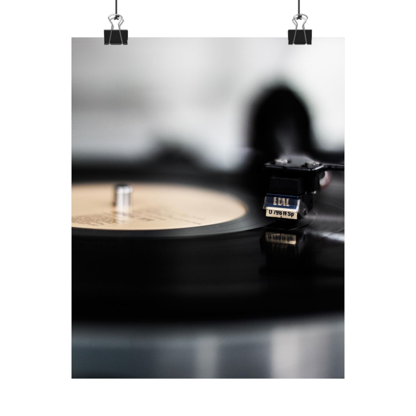 Close-up of a vinyl record player with a record on a dark surface.