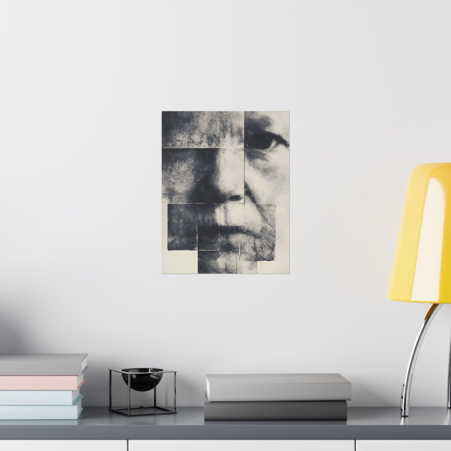 Collage of a face on a wall above a desk with books and a lamp.