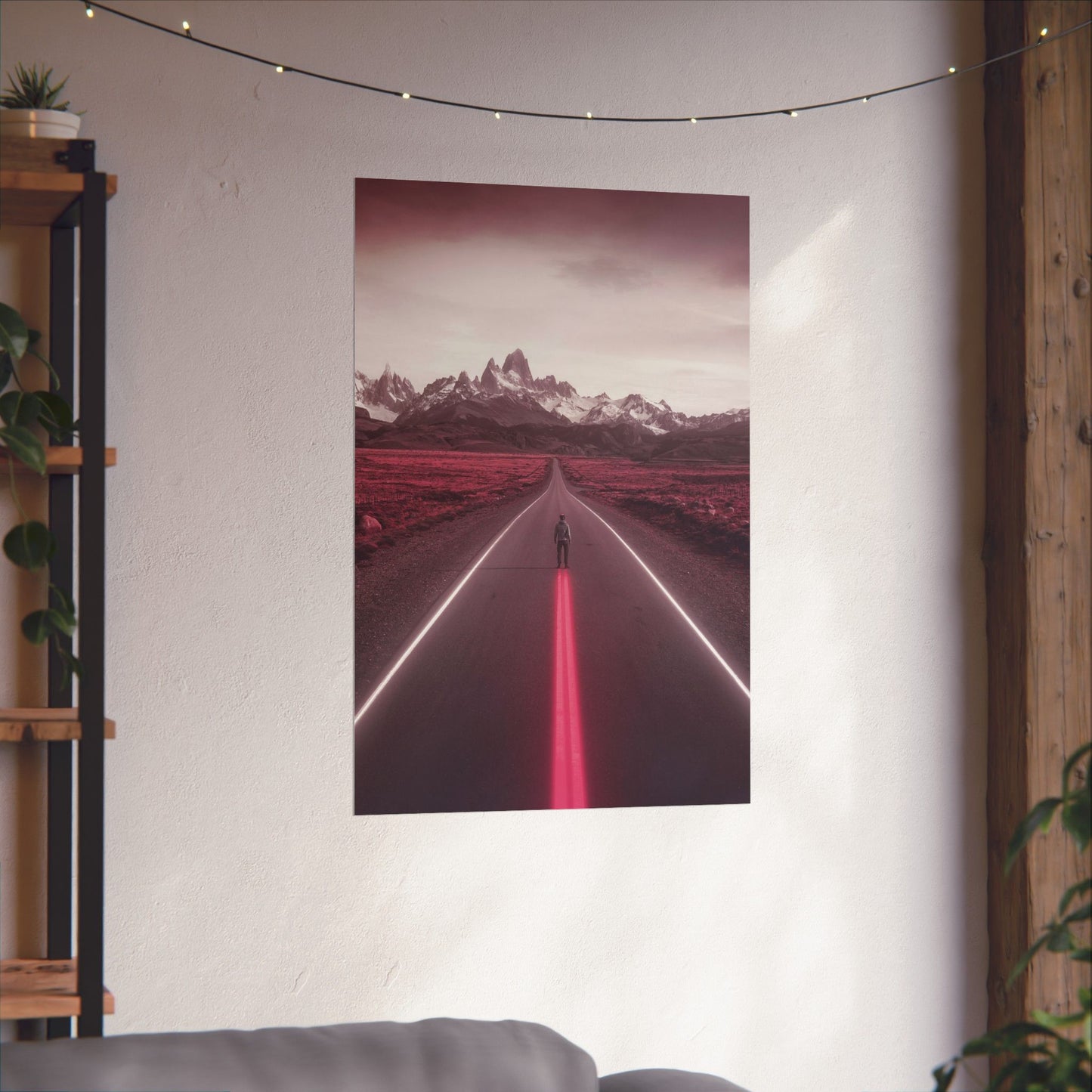 Poster of a road with mountains and red lights hanging on a wall.
