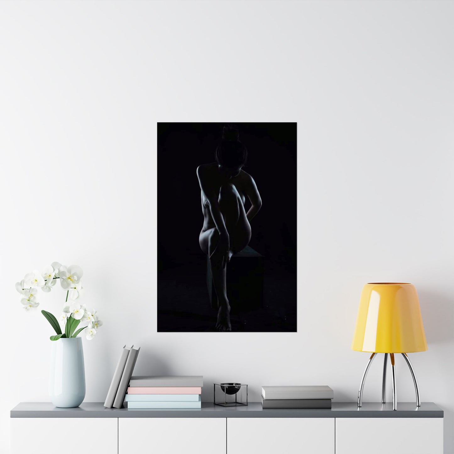Silhouette of a nude figure on a black background in a modern interior setting.