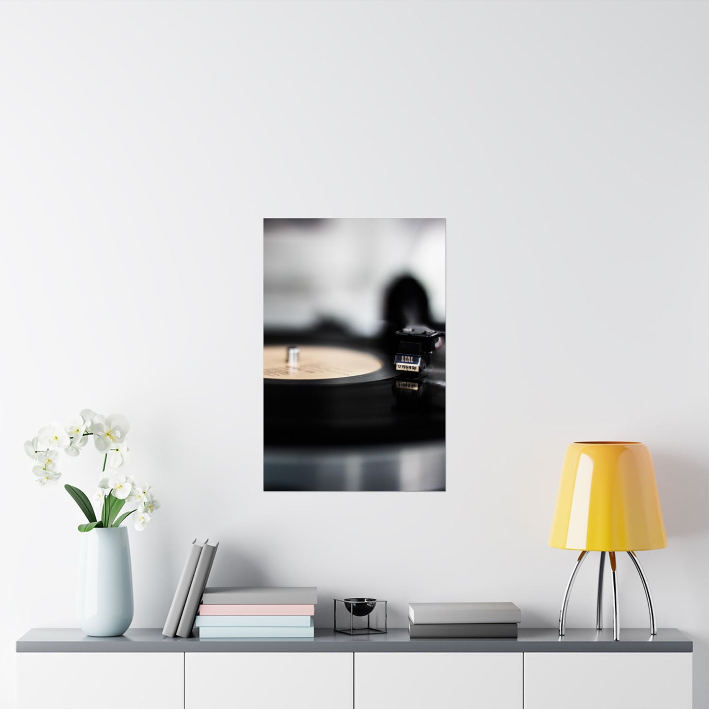 Framed black and white photo on a wall above a shelf with decor items.