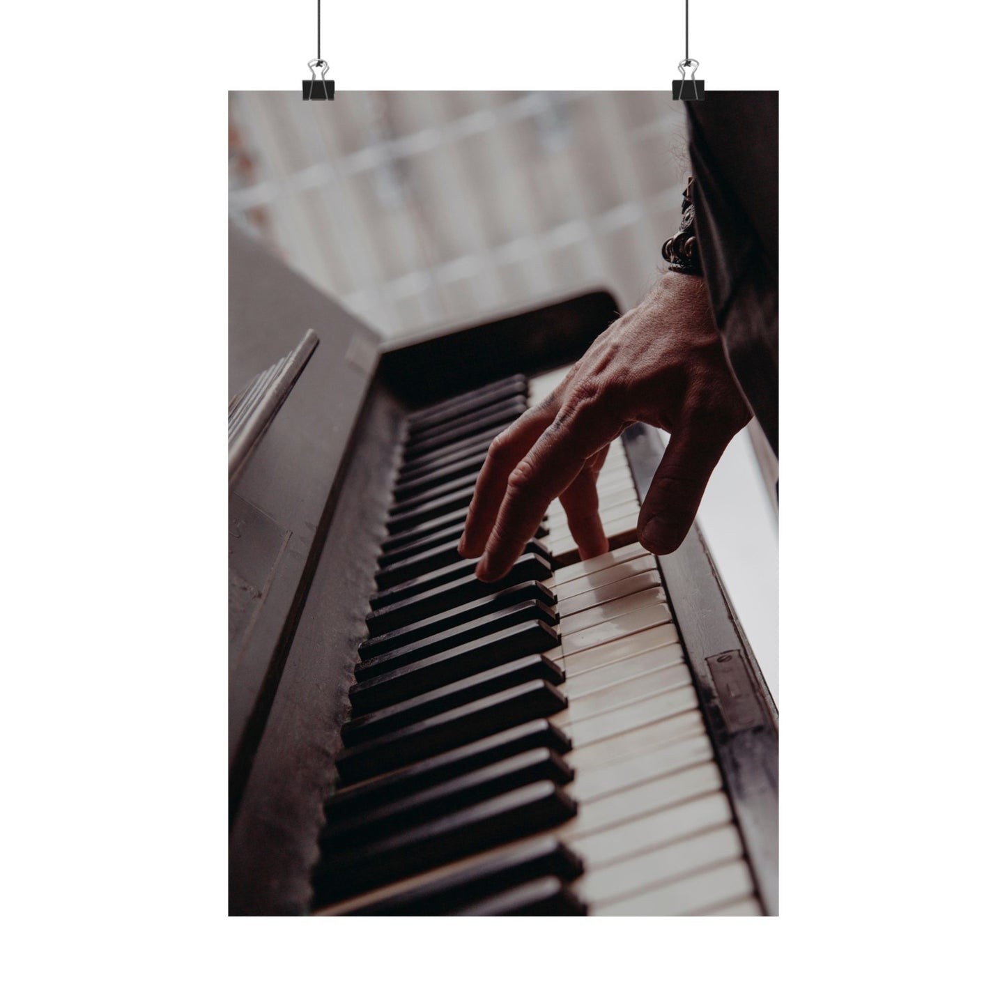 Hand playing a piano with a blurred background