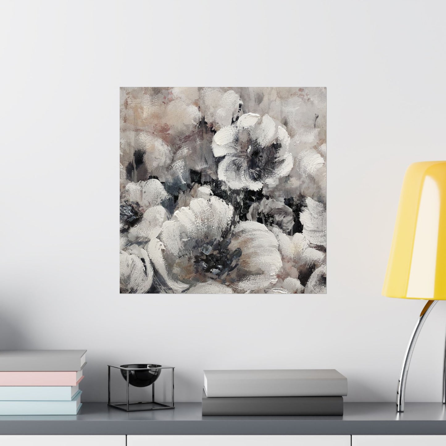 Abstract floral art print on a wall above a shelf with books and decor items.