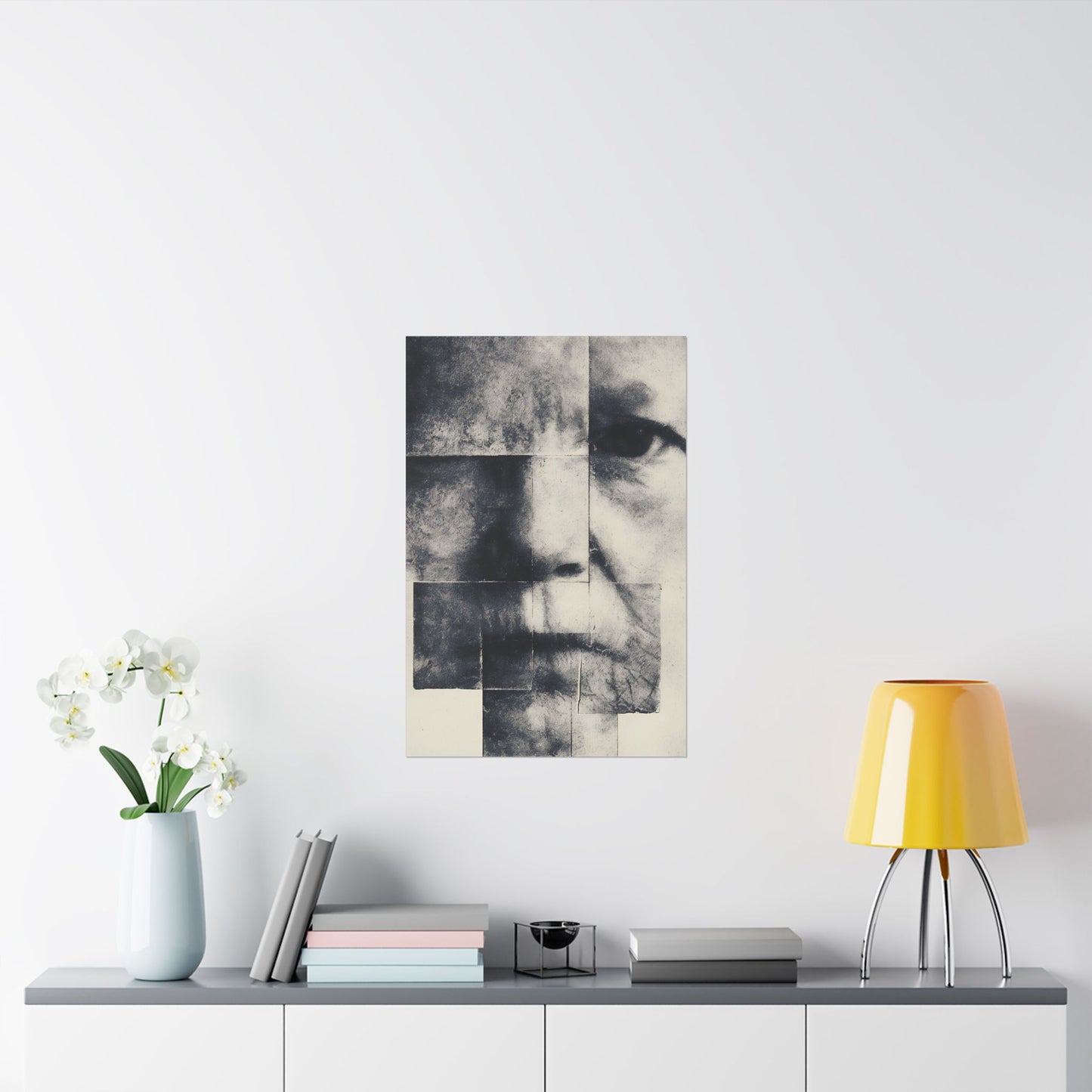 Abstract art piece of a face on a white wall above a shelf with decor items.